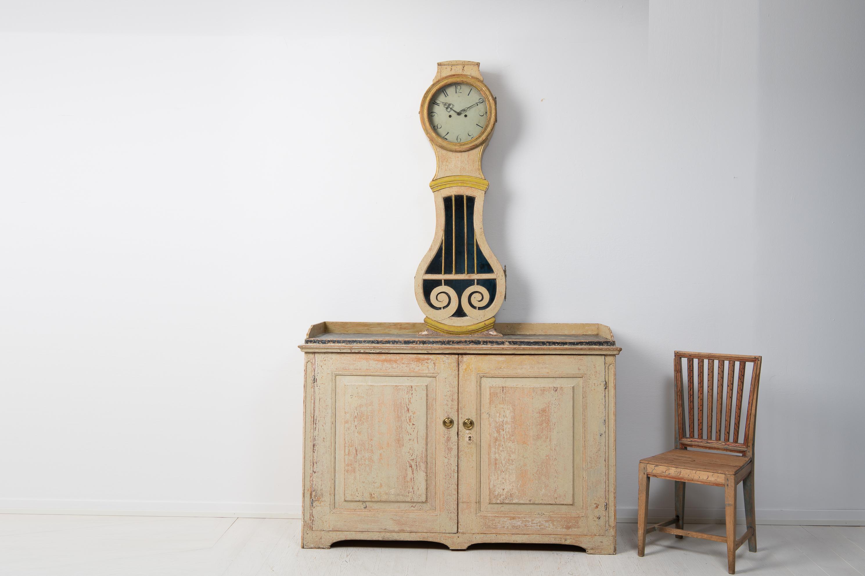 Rare cabinet d'horlogerie antique de Suède fabriqué pendant la période de transition entre l'époque gustavienne et l'époque de l'empire. Le meuble provient du nord de la Suède et a été fabriqué entre 1820 et 1840. Le meuble inférieur a deux portes