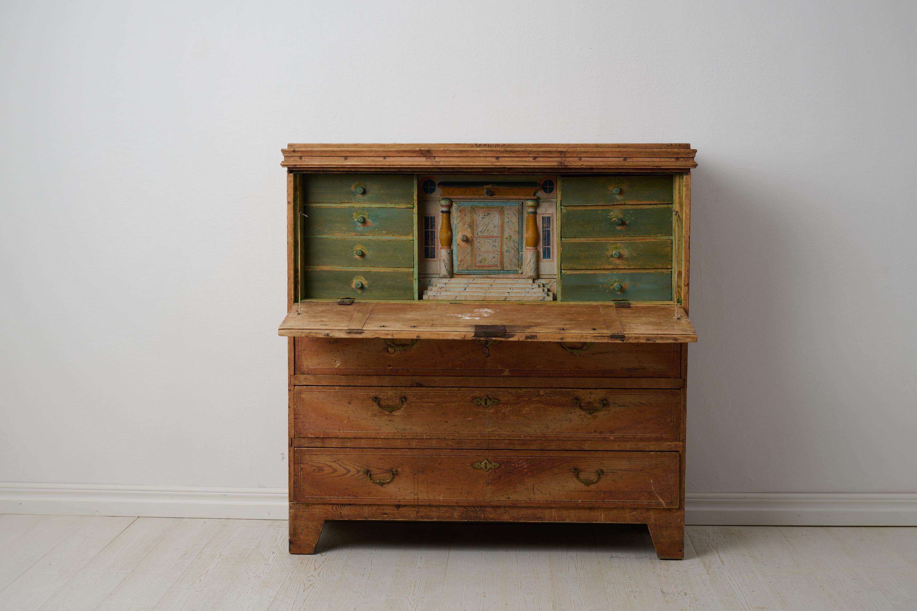 Rate antique Swedish secretary desk in folk art made around 1830 in northern Sweden. The secretary is made by hand with a frame in solid pine. The interior has multiple small drawers and a door in the centre – which has never had any hinges. The