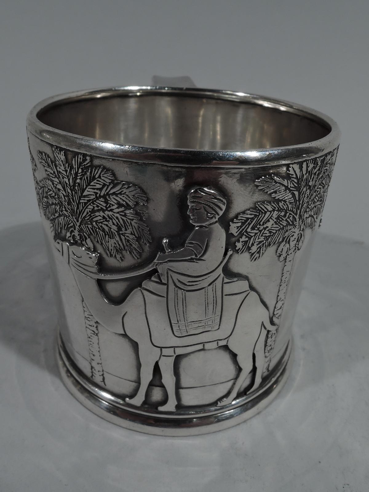 Rare sterling silver baby cup with Nativity motif. Made by Tiffany & Co. in New York, circa 1920. Drum form with bracket handle and skirted foot. Acid-etched frieze depicting three turbaned kings riding camels with palm tree colonnade in background.