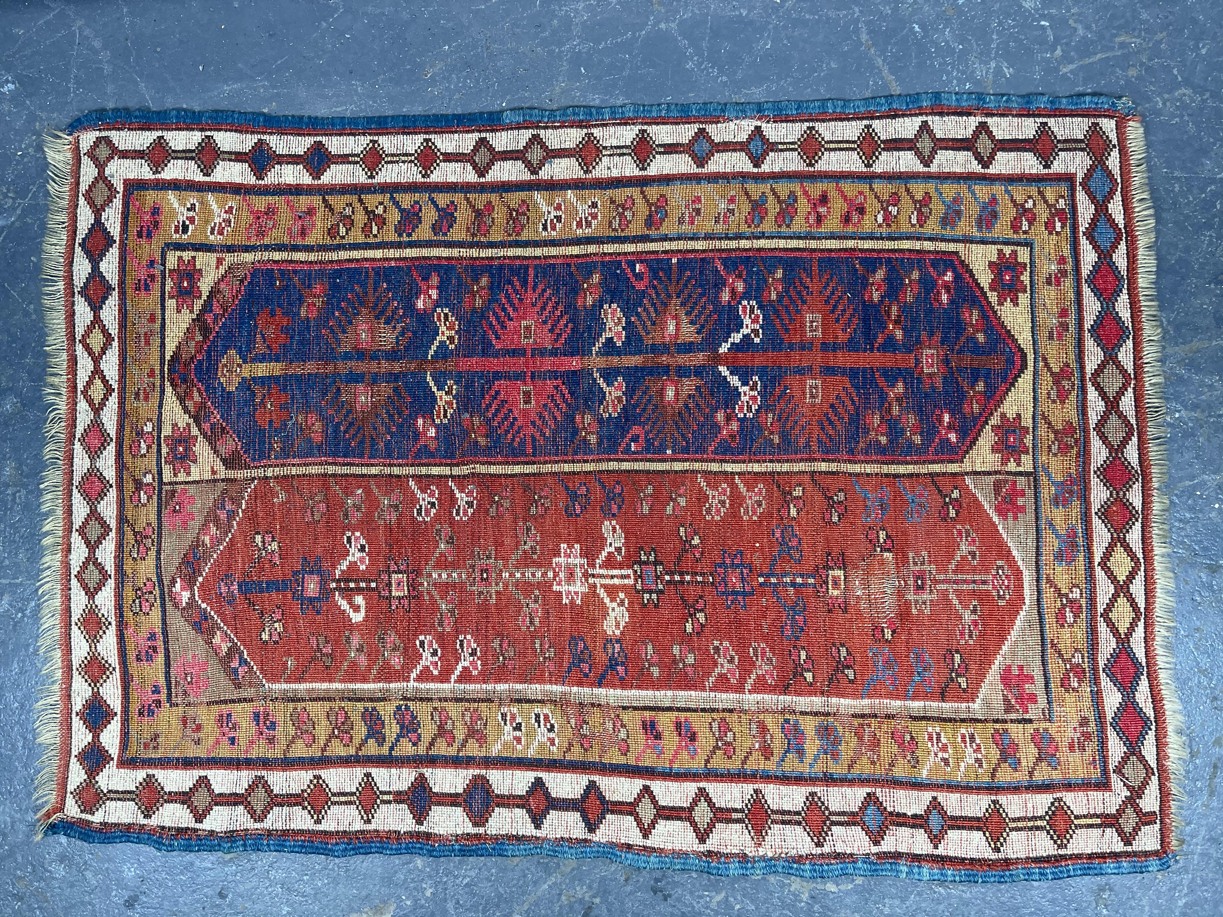 Makri Rug, Southwest Anatolia, late 19th century, two elongated rectangular panels each inset with four radiating medallions in navy and royal blue, red, gold, black, red-brown, and blue-green, gold geometric motif border, (slight wear spot) 