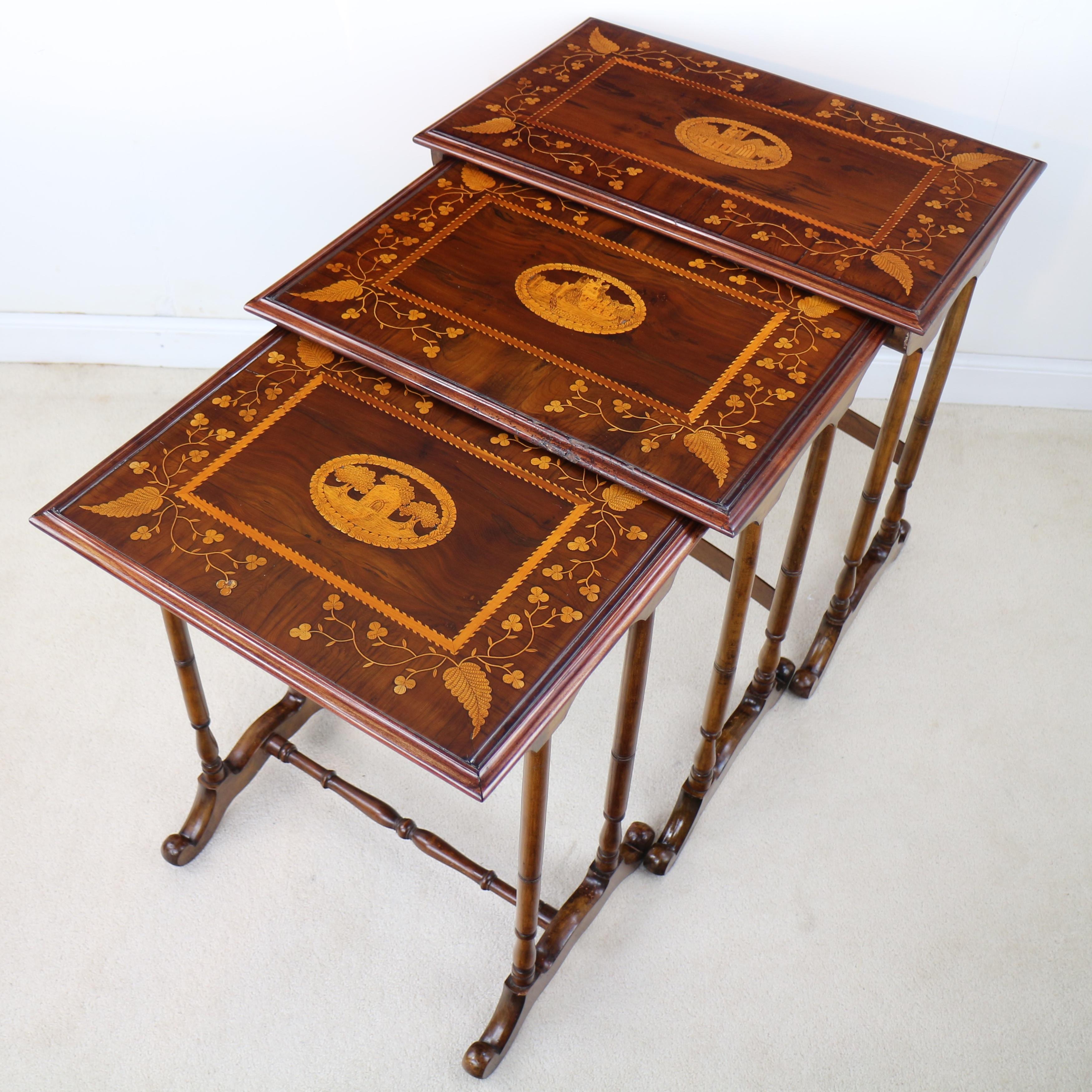 A very rare nest of three Irish Killarney ware arbutus and yew marquetry tables dating to the mid-19th century. Each inlaid to the tops with ferns and trailing shamrocks and centred with oval vignettes of romantic scenes of Muckross Abbey, Ross