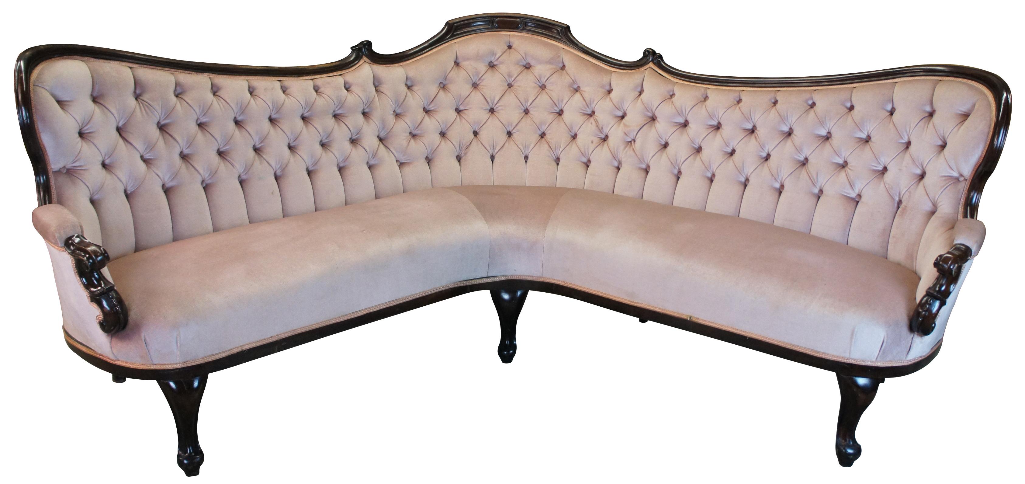 Monumental Victorian corner parlor sofa featuring serpentine walnut frame with S scroll carved and padded arms. Features queen anne legs and tufted upholstery. Circa 1870s

102