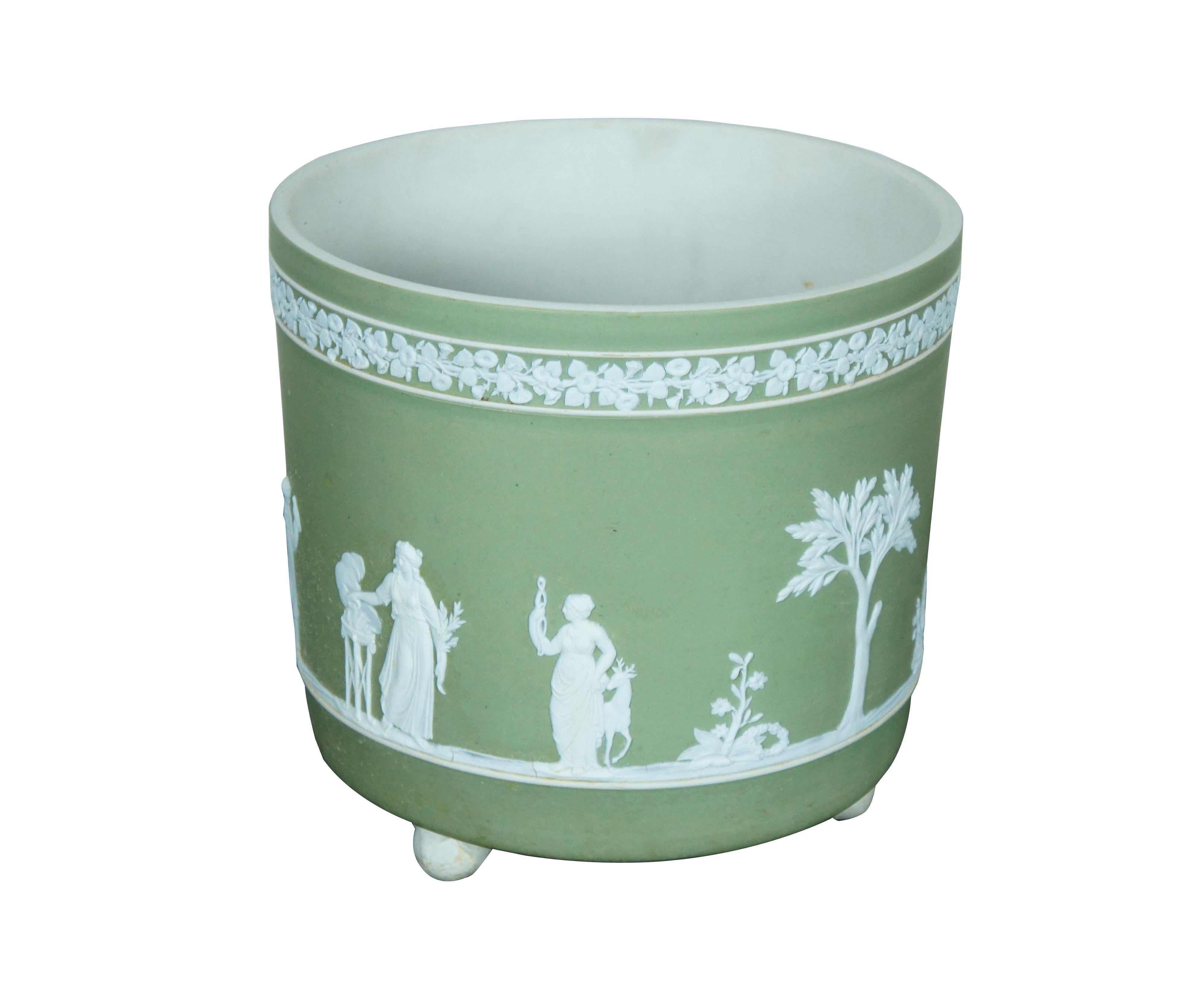 Rare antique Wedgwood England jasperware planter / cachepot / jardiniere. White on green jasperware featuring Wedgwood's traditional neoclassical array of figures and trees below a band morning glories. Cylindrical form with ball feet. Marked 1/1 on