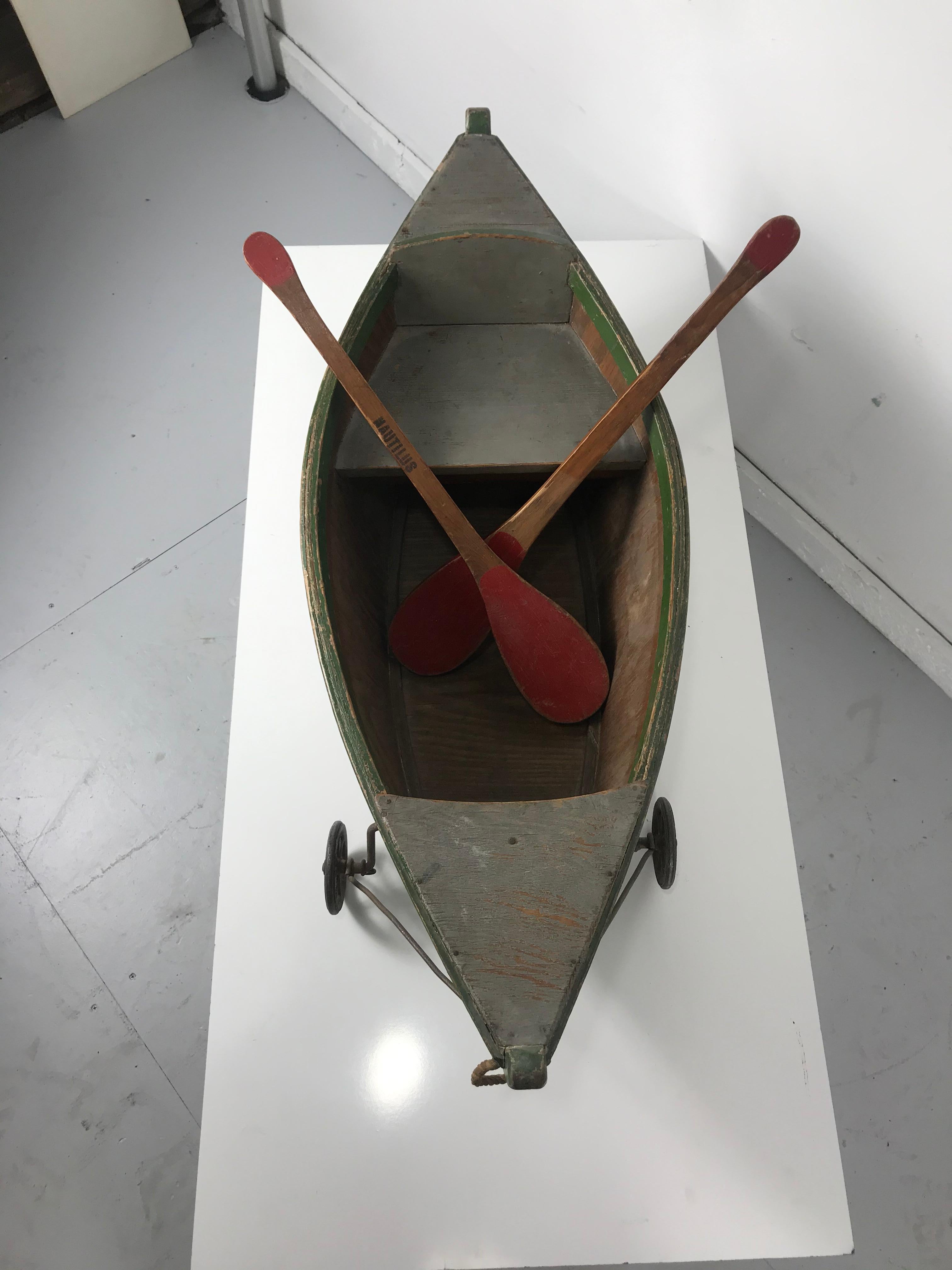 Rare antique wooden child's ride on wooden toy boat by Nautilus Toy Co. London wonderful Folk Art object. 1920s ride on toy made by the Nautilus Toy Company, all wood construction, beautiful original paint and surface, retains its original oars also