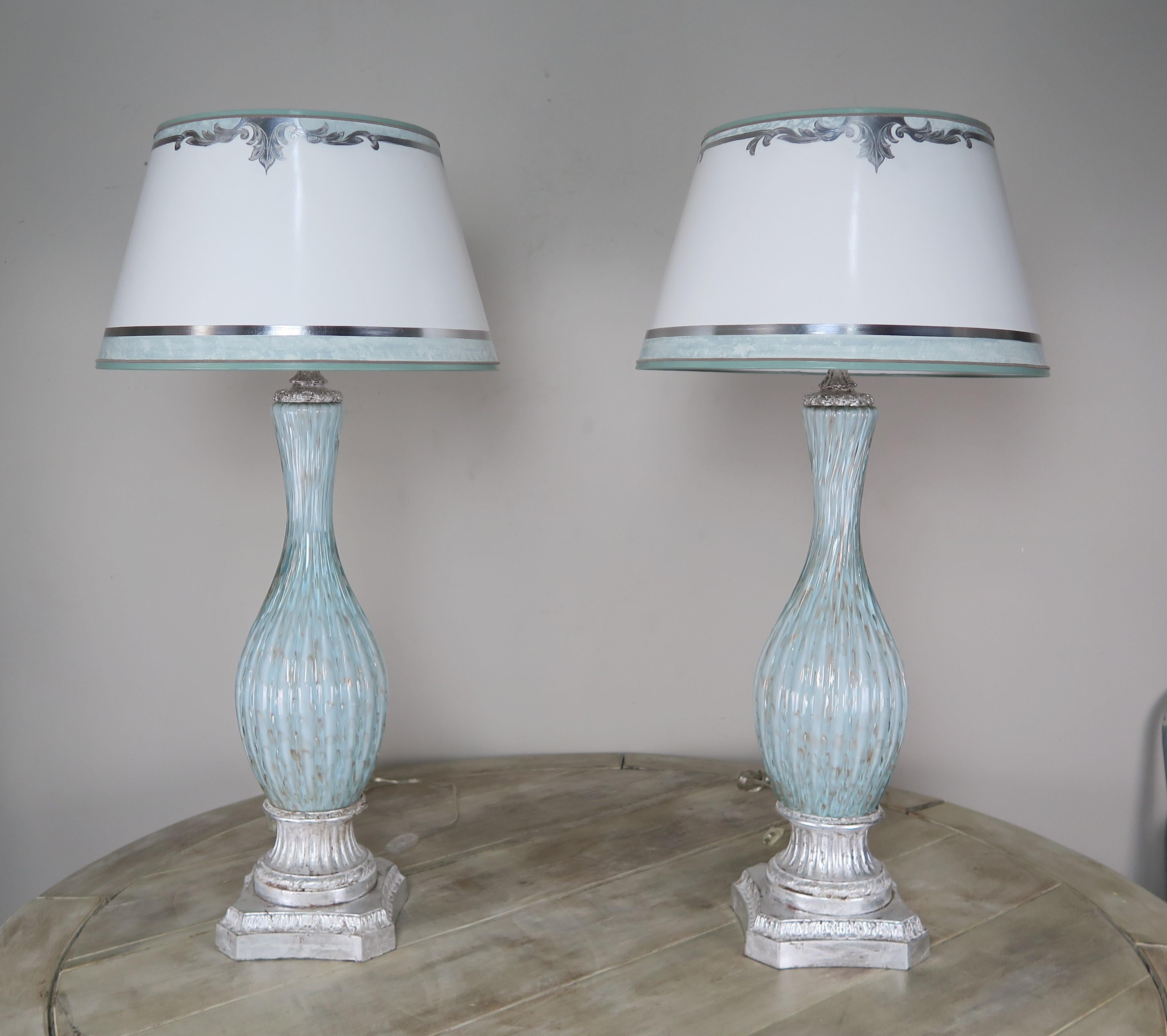 Pair of rare aquamarine colored handblown Italian Murano Lamps on silvered bases. The lamps are crowned with hand painted parchment shades with coordinating aquamarine and silver detailing.