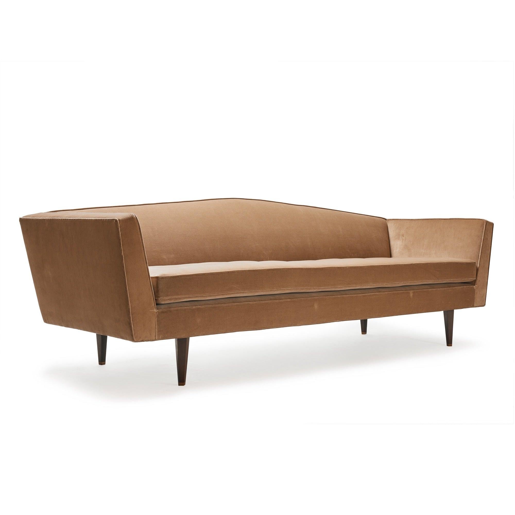 A rare upholstered sofa with an arched back on pentagonal shaped mahogany legs.