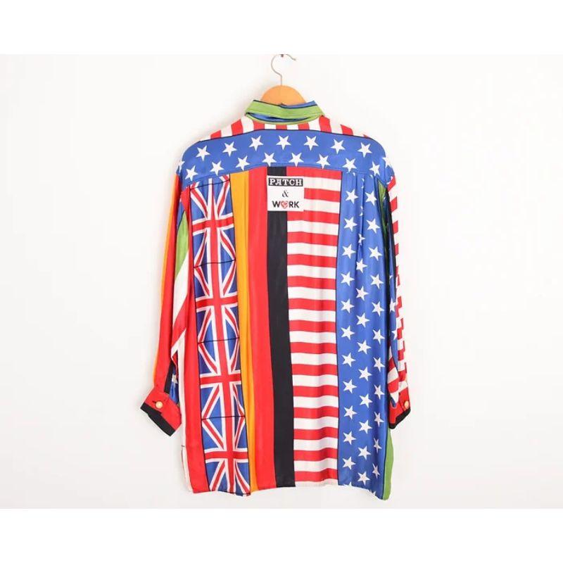 Superbe chemise d'archives vintage Moschino à motif 'World Flags', une pièce synonyme de la scène Garage Rave britannique dans les années 1990. Cette chemise est réalisée dans un tissu satiné imprimé avec des manches longues et des boutons sur le