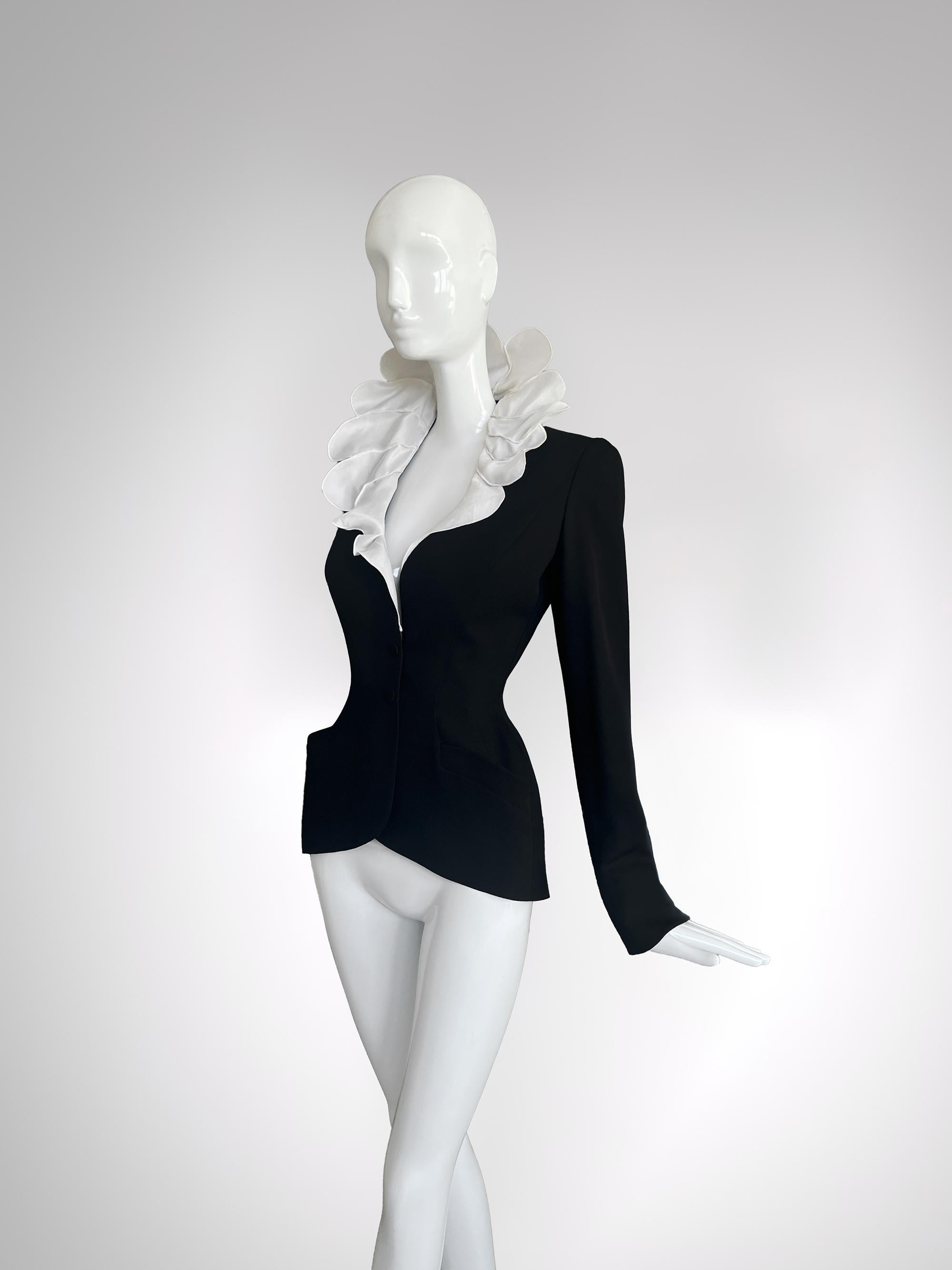 Thierry Mugler SS 1997 black wool jacket with super dramatic beautiful silk collar.
With a silhouette sculpted to perfection and a collar that defies gravity and convention, this piece encapsulates the theatrical power of thierry Mugler‘s vision at