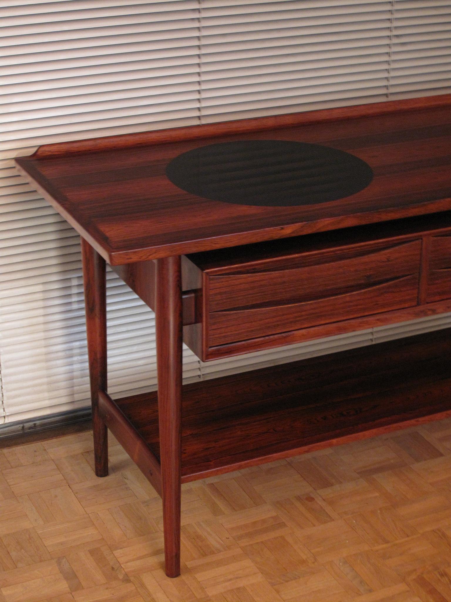 An incredibly handsome and very seldom seen Console table designed by Arne Vodder and produced by P. Olsen Sibast, Denmark.

Produced from Brazilian rosewood with four drawers finished in Vodder’s signature style which attractively float within