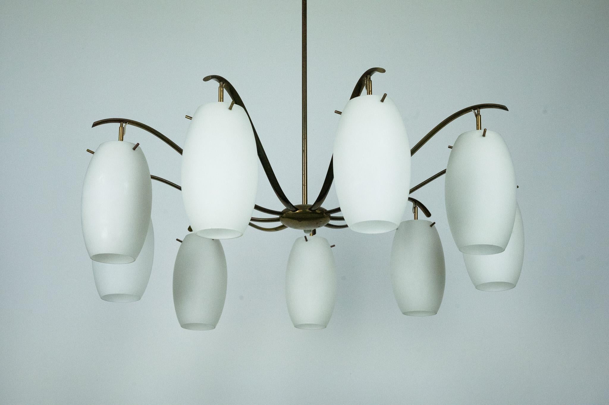 Sophisticated nine-light chandelier designed by Angelo Lelii for Arredoluce Monza, Italy, 1950s. The elegant brass frame features gracefully arched arms supporting triplex opaline glass diffusers with a soft, organic shape. A wall sconce from the