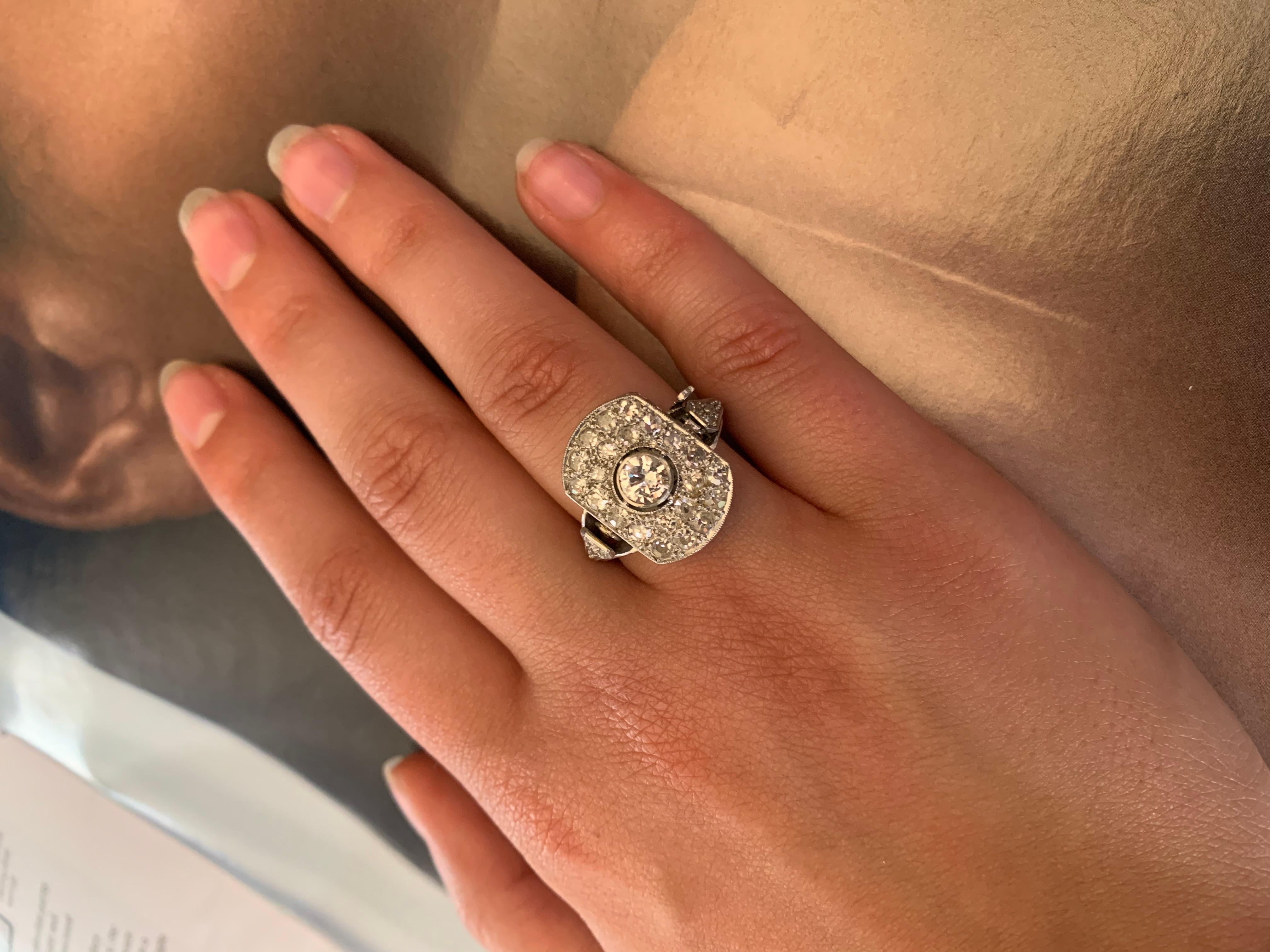 This striking, elegant Art Deco cocktail ring holds a delightful surprise- a miniature watch is revealed when you open the front diamond set filigree panel, making it a marvelous conversation piece. This unusual time piece is complex and well