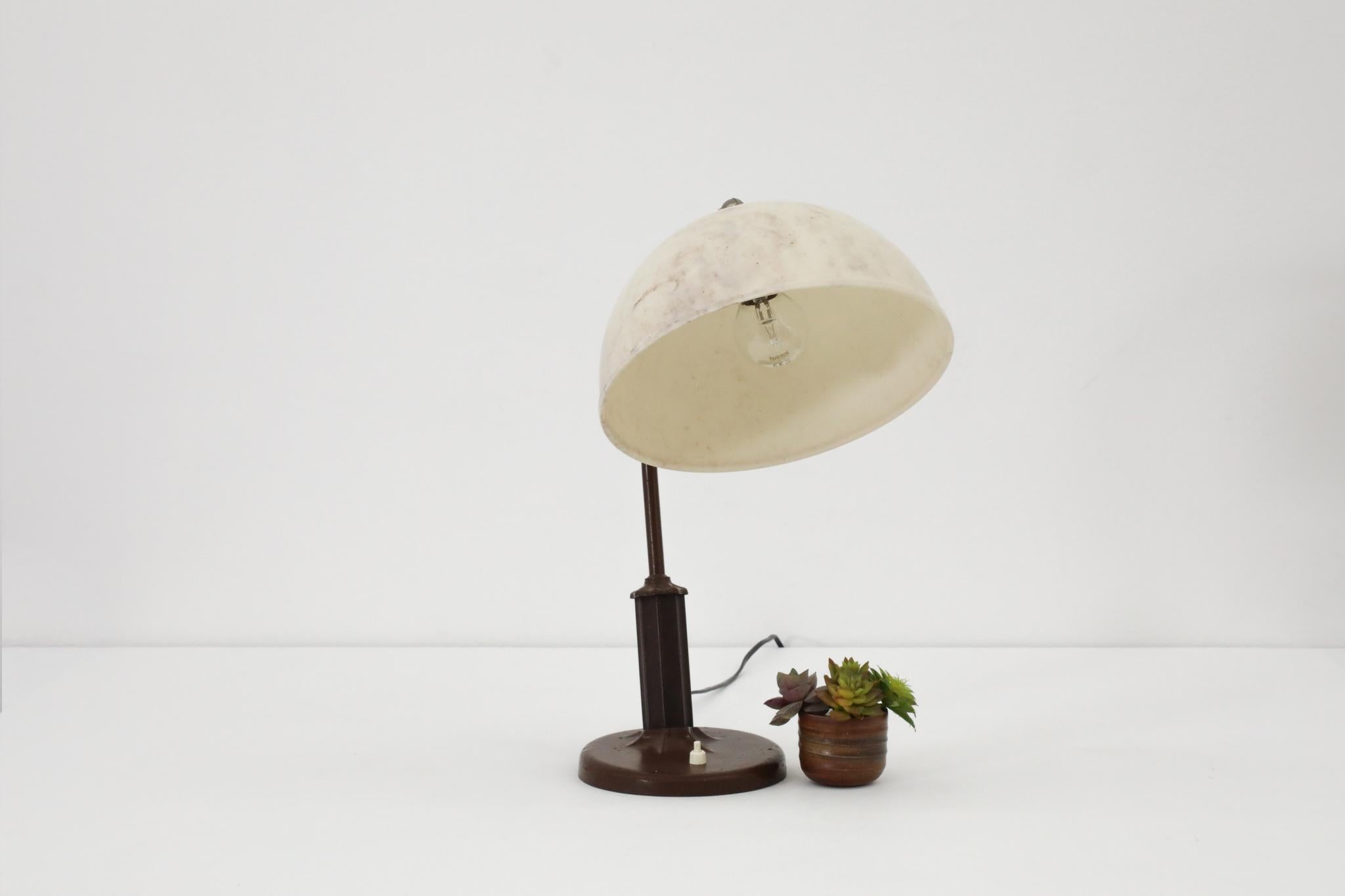 Rare Bakelite Art Deco table lamp with decorative marble design bakelite dome shade. Adjustable shade for directional light on brown enameled metal base with standard size medium base bulb (60W max). In original condition with some visible patina