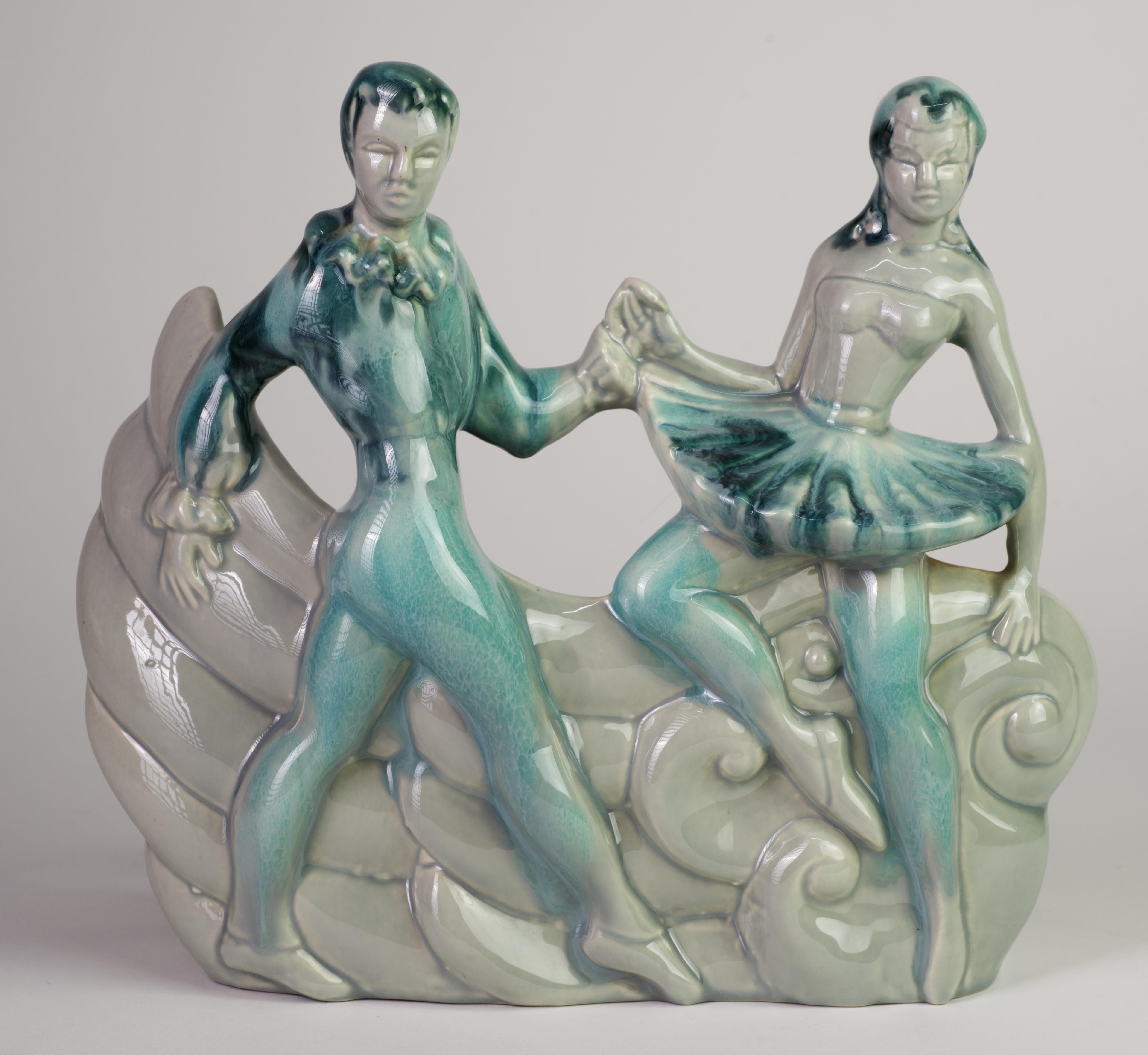  Rare ceramic TV lamp features two ballet dancers, man and woman, in front of abstract graphic background, sculpted in Art Deco style. Other examples of lamp in this shape were done in black, black with some drip glaze details, and dark green