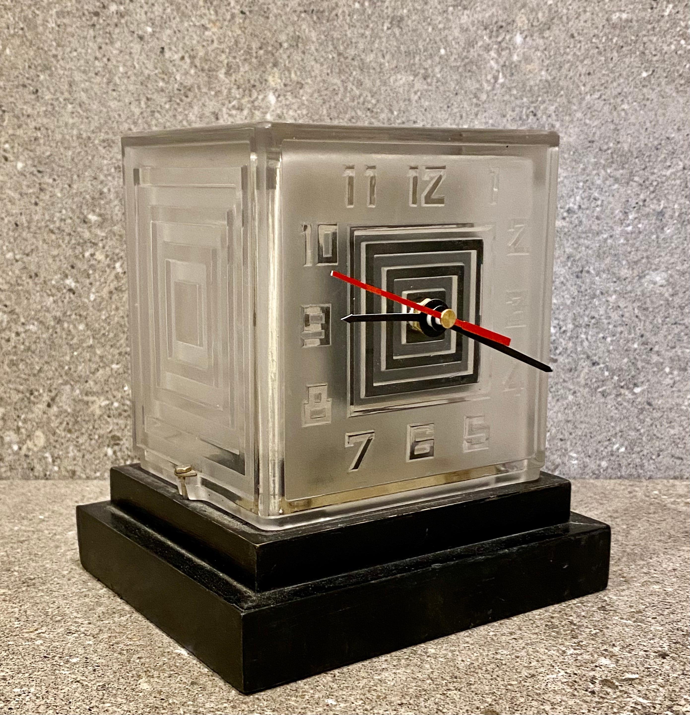 A Art Deco modernist Bulle clock by P.M.Favre. One of the first battery operated clocks of the 1930's. The frosted glass case has etched stylised numerals. The stepped wooden plinth is ebonised.
Although the original battery size is no longer