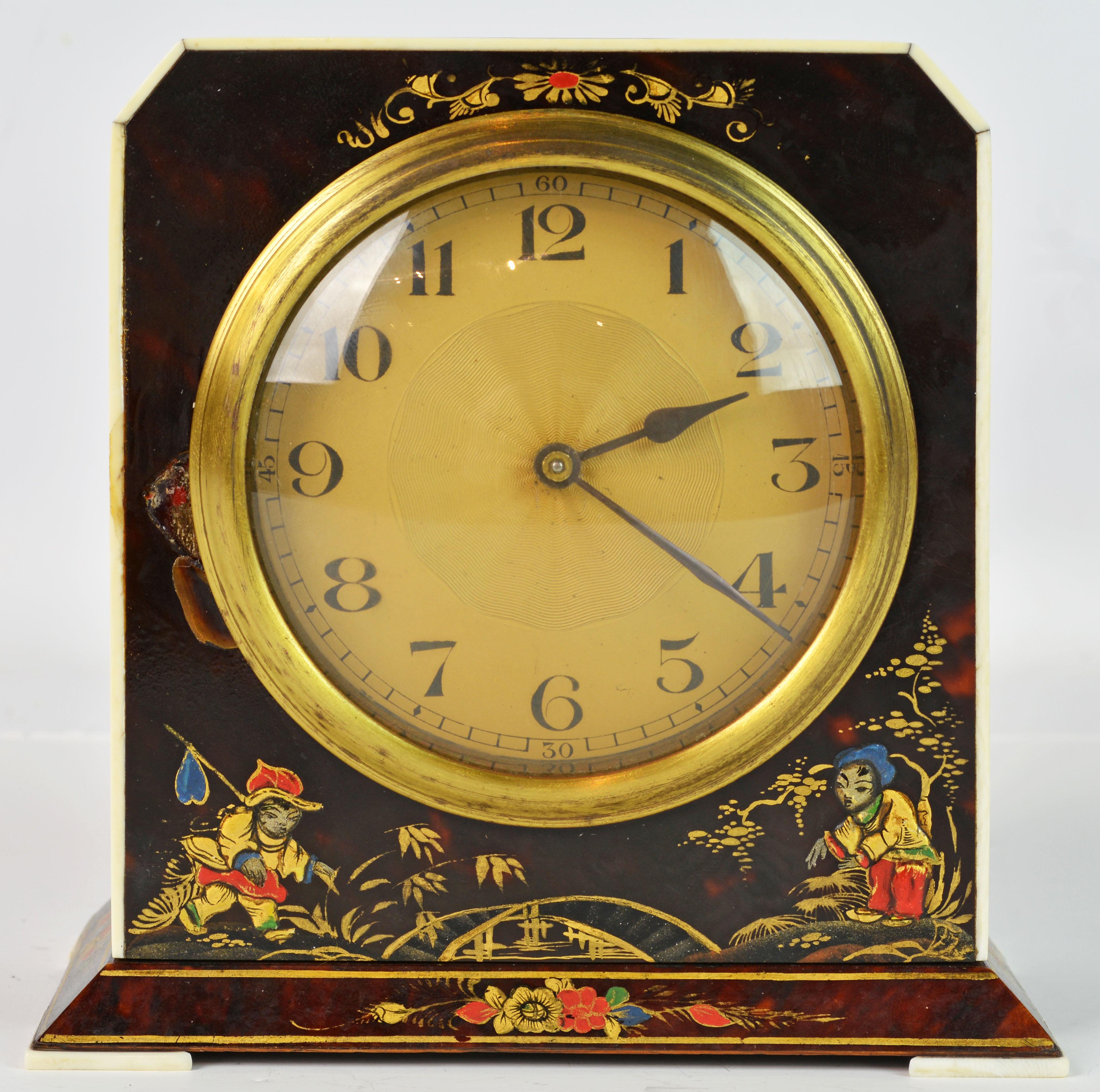 This very stylish clock would have been made in the Art Deco period around 1930. It is made of wood covered with chinoiserie lacquer and gilt decorated tortoise shell with an ivory trim around the front and slices of ivory for feet on each corner of