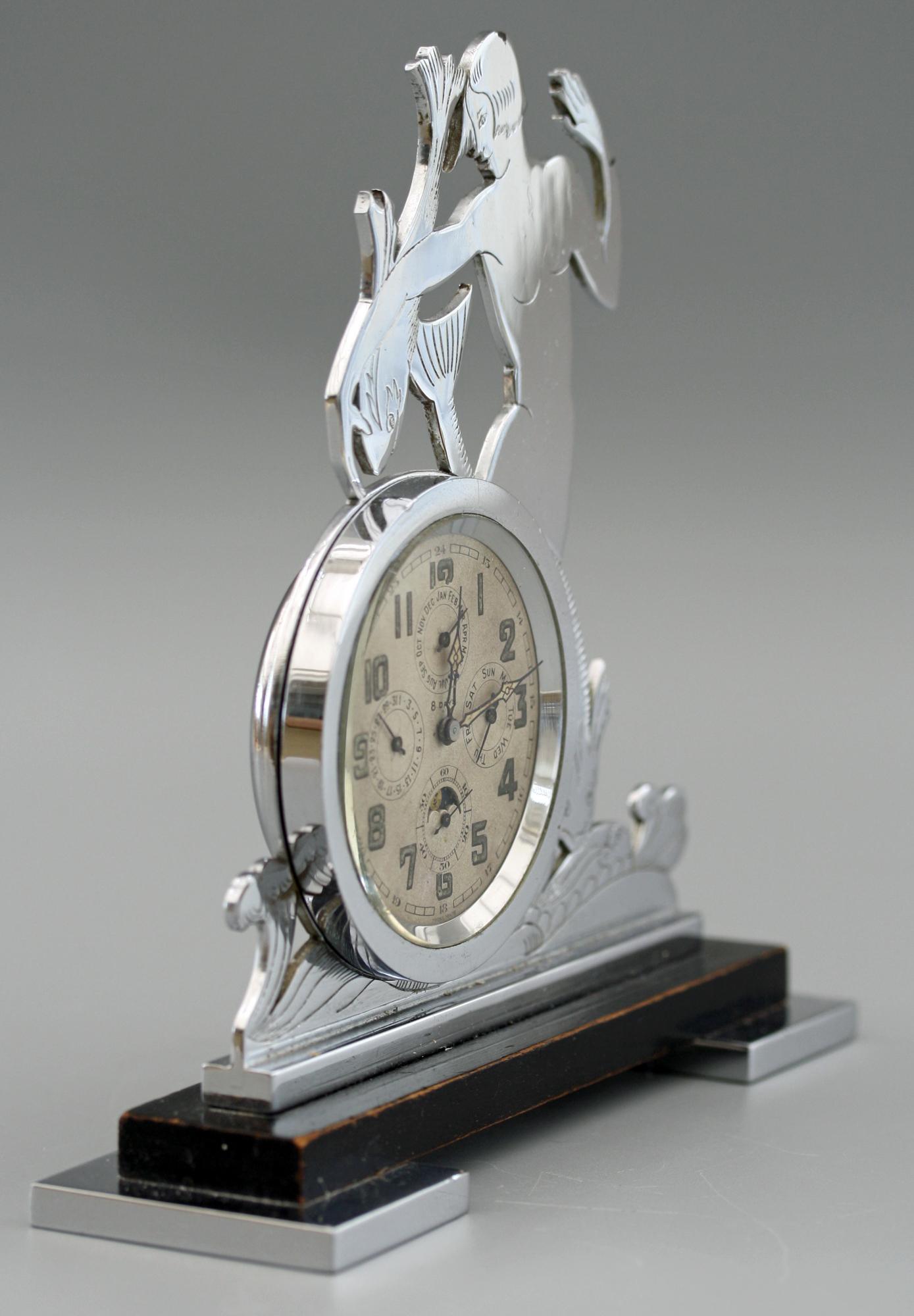 A extremely rare and very stylish Art Deco 8 day clock with four complications including moonphase dating from around 1930. The cock stands mounted on two rectangular polished chrome feet with a wooden base supporting a chrome cut out of a mermaid