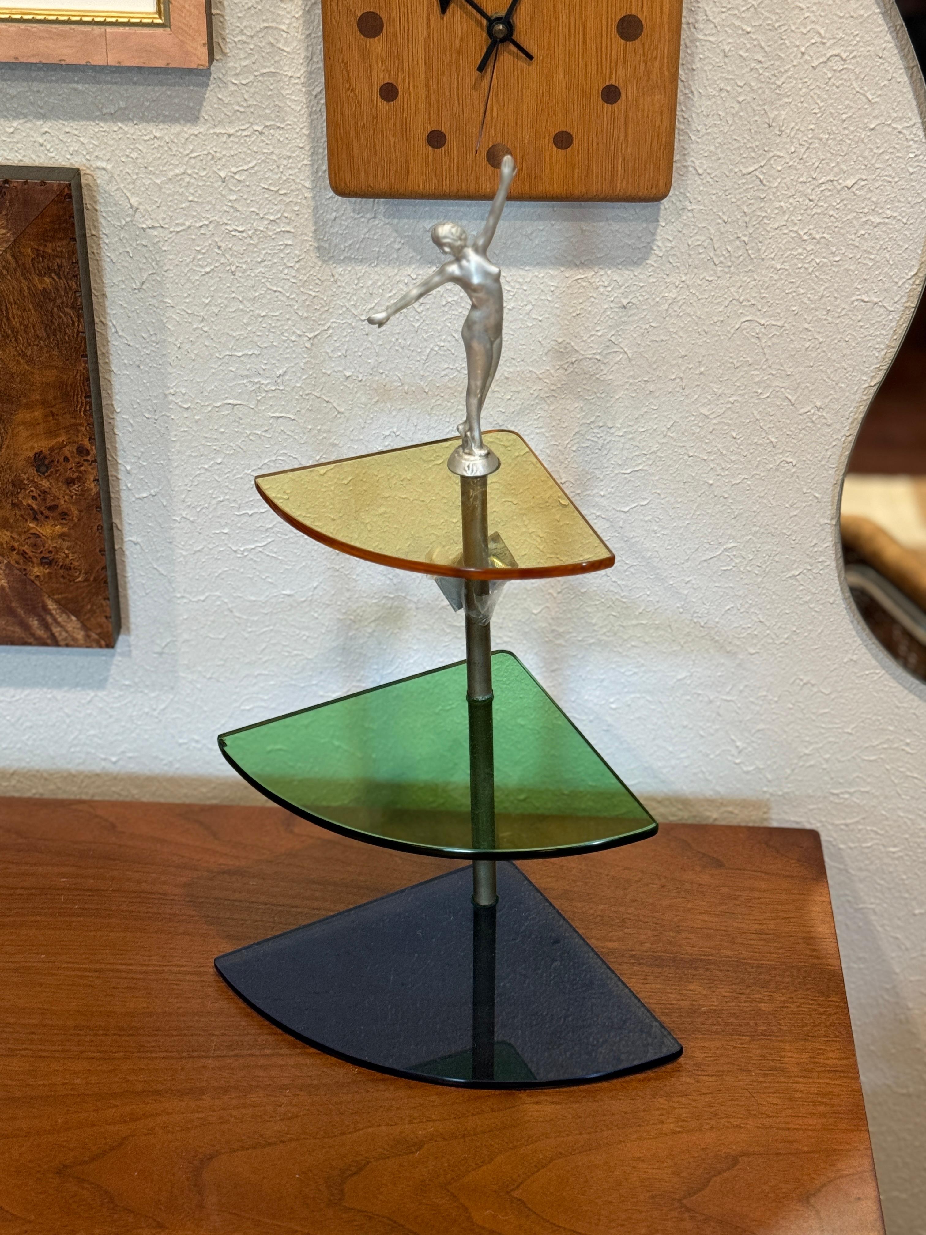 Seltenes Art Deco Eckregal aus buntem Glas für die Wand mit einem Flapper Girl auf der Oberseite, ca. 1930er Jahre. Inklusive Befestigungsmaterial zum Aufhängen. 

17