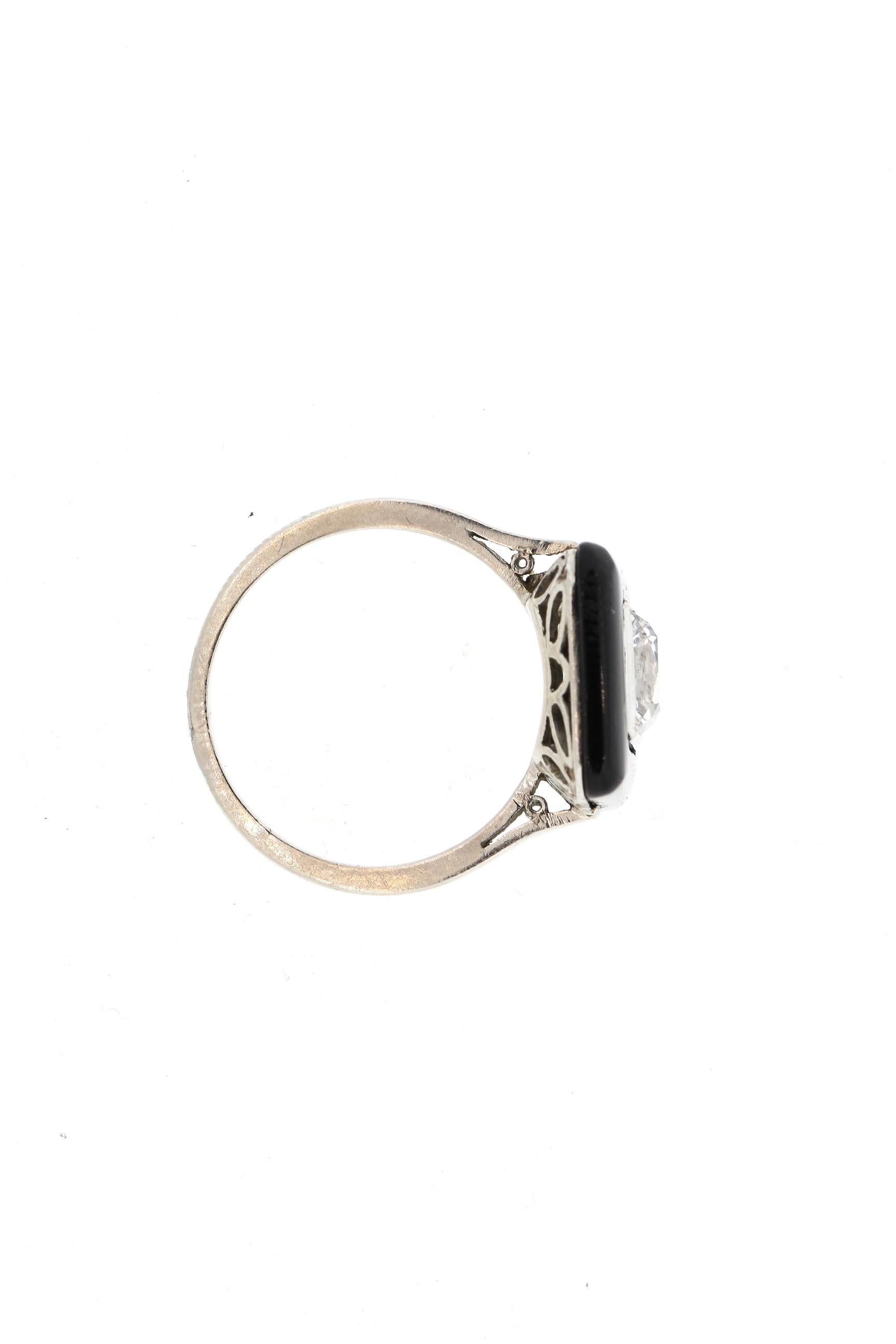 A rare single large French cut diamond surrounded by a table cut onyx frame set in platinum with French hallmarks. This gorgeous ring is set with a French cut diamond weighing approximately 1.05 carats that is estimated to be an E to F color and VVS