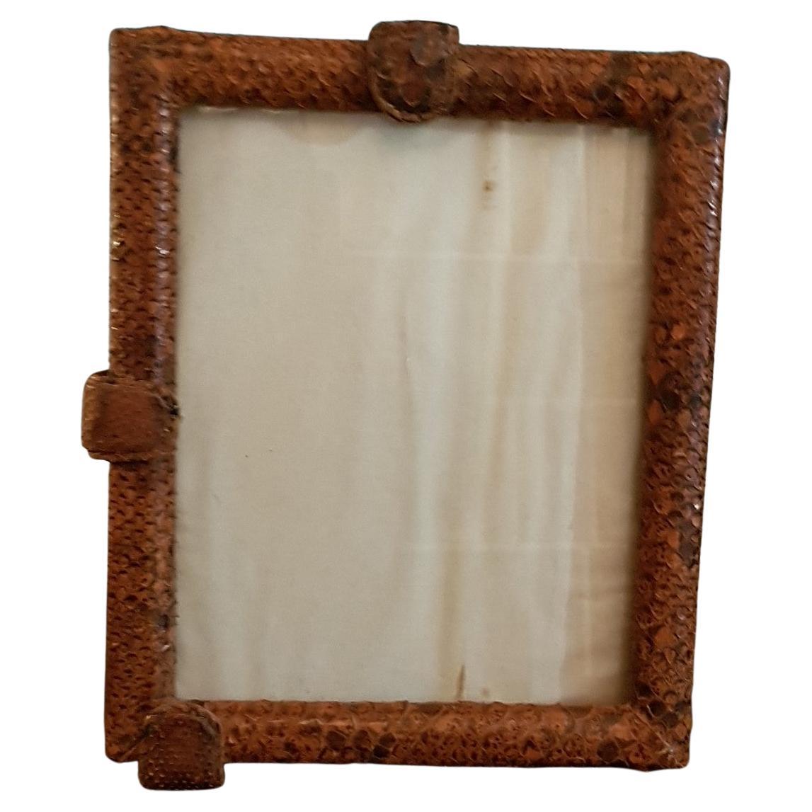 Fine quality and rare snakeskin picture frame with glass and leather stand at the back. The snakeskin clad side clips move to enable you to place the picture in the frame. The snakeskin is aged and has an amazing tactile quality to it, rarely found