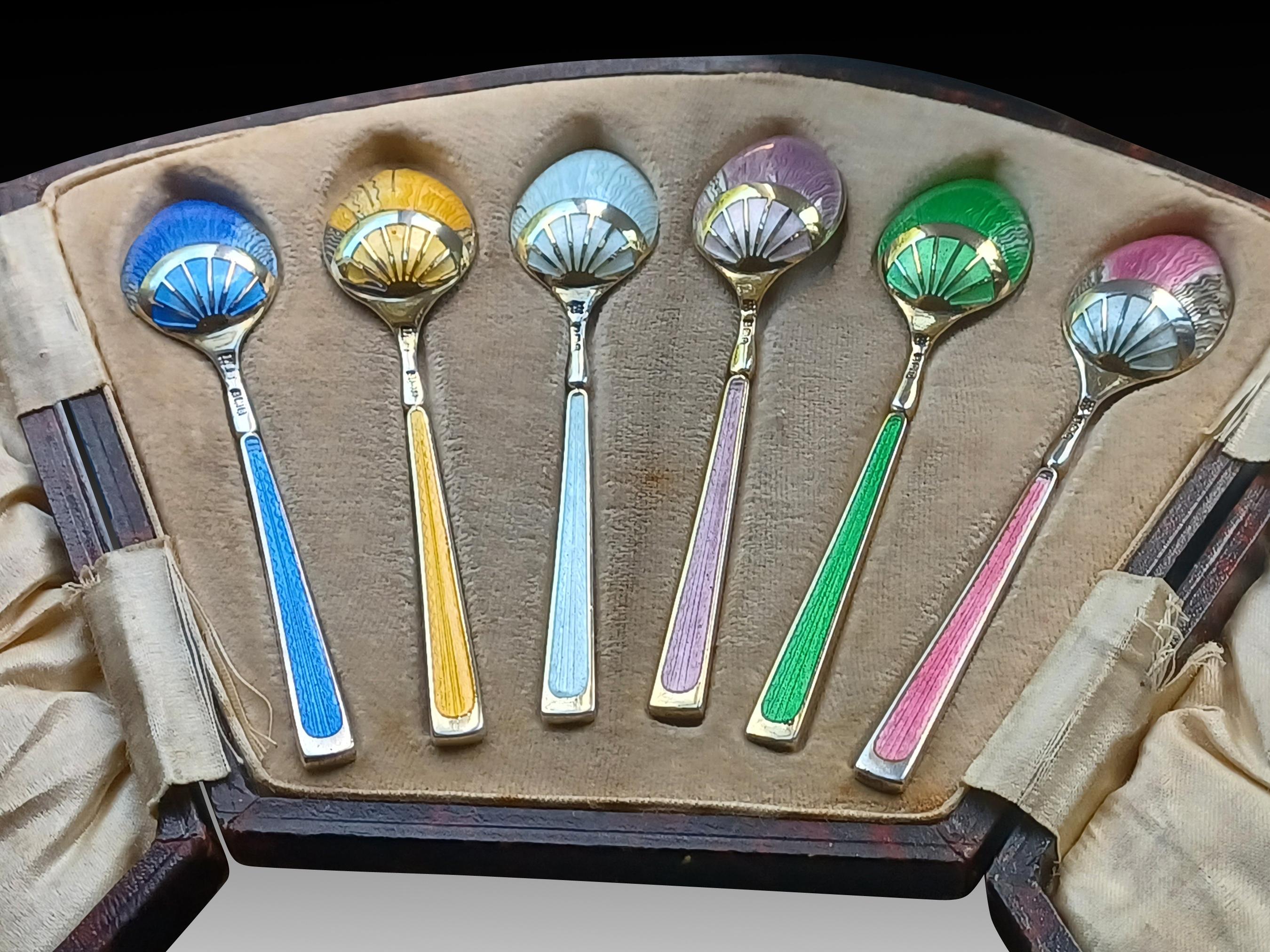 Rare Art Deco Gilt Guilloche Enamel Teaspoon Set in Original Leather Case 

Of pure 1920s extravagance with a custom rainbow of gilt, guilloche enamelled Art Deco spoons in the English style, all contained in the original tooled brown fanned leather