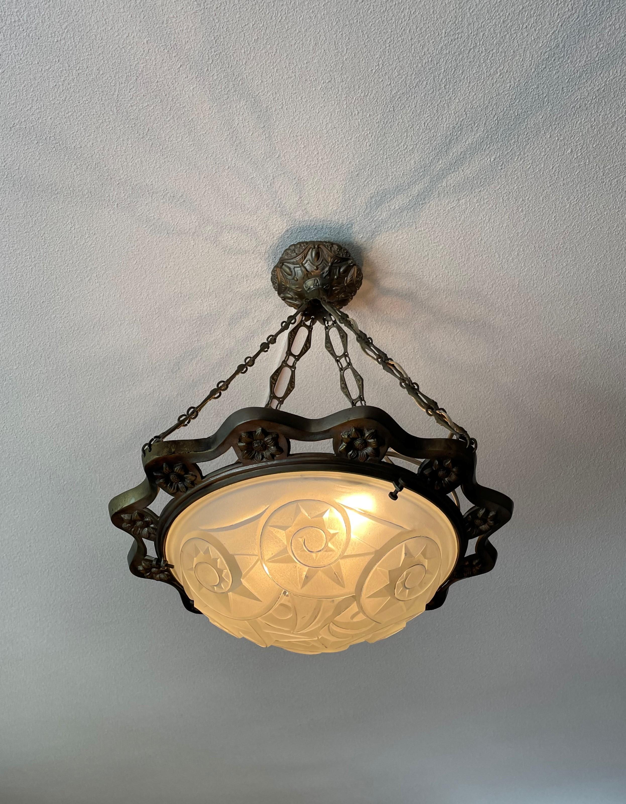 Rare antique French Art Deco pendant with flower theme.

This large and early Art Deco three-light flush mount is of great quality and design. It comes with the original nickeled bronze chains and flower decorated ring on the outside. The bronze and