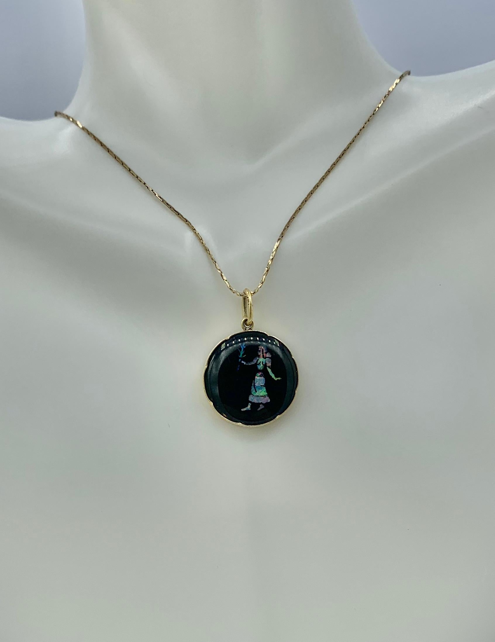 THIS IS A WONDERFUL AND VERY RARE INLAID BLACK OPAL PENDANT WITH AN IMAGE OF A WOMAN CARRYING A FLOWER.  THE PENDANT IS BLACK ONYX WITH INLAID BLACK OPAL GEMS AND IS SET IN 14 KARAT GOLD.  THE JEWEL IS A MASTERPIECE OF ART DECO JEWELRY DESIGN.  