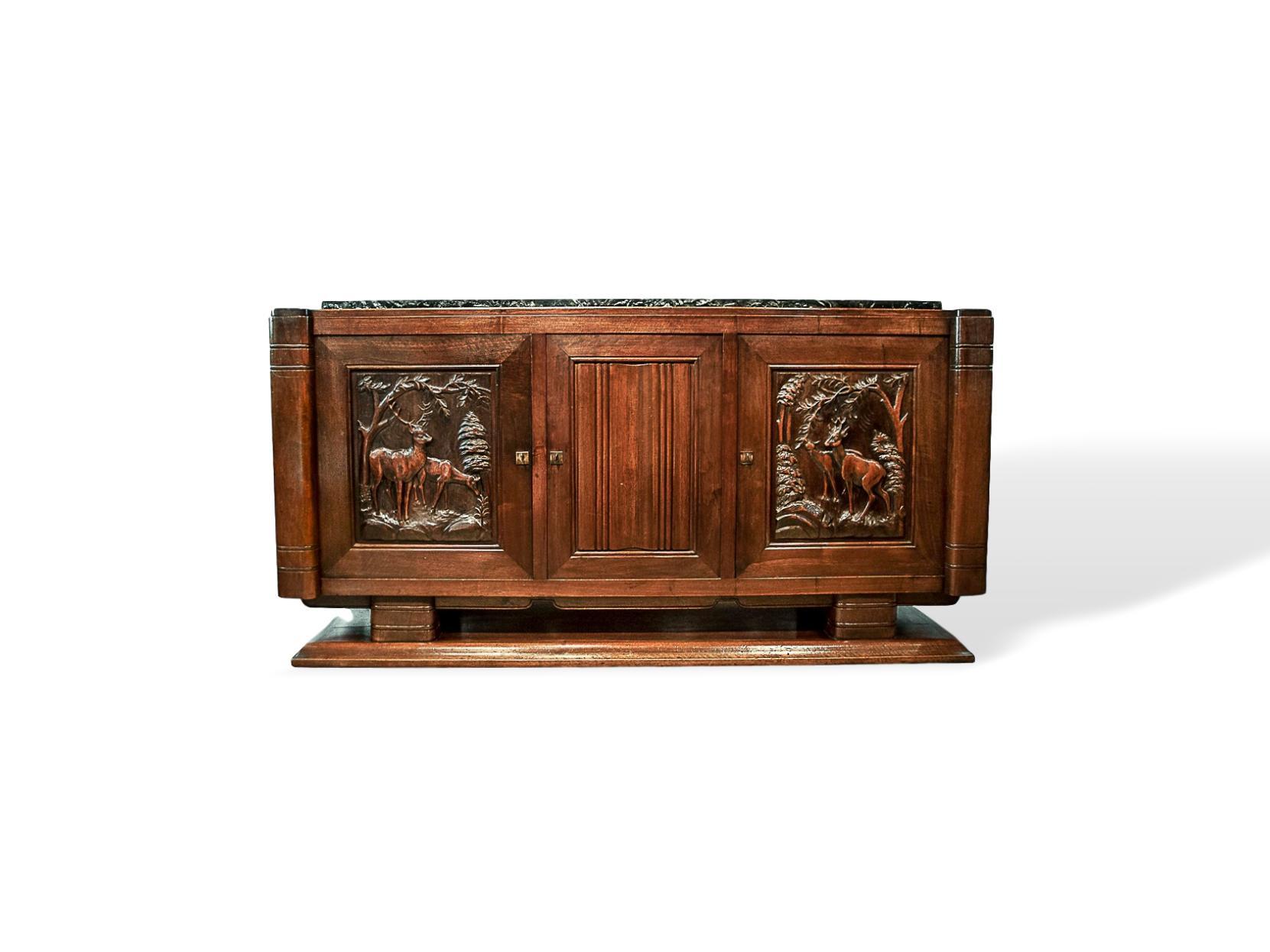 Rare French Art Deco midcentury solid walnut credenza sideboard, circa 1930. Central door with linen fold panel, hand carved stylized deer in a woodland setting to left and right cabinet doors, flanked by large 