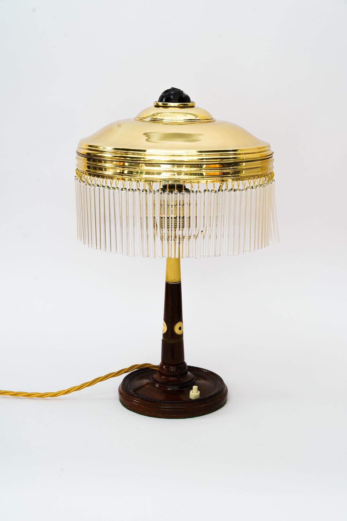 Rare Art Deco table lamp with glass sticks, Vienna, around 1920s.
Wood polished.
Brass polished and stove enameled.
The glass sticks are replaced (new).
 