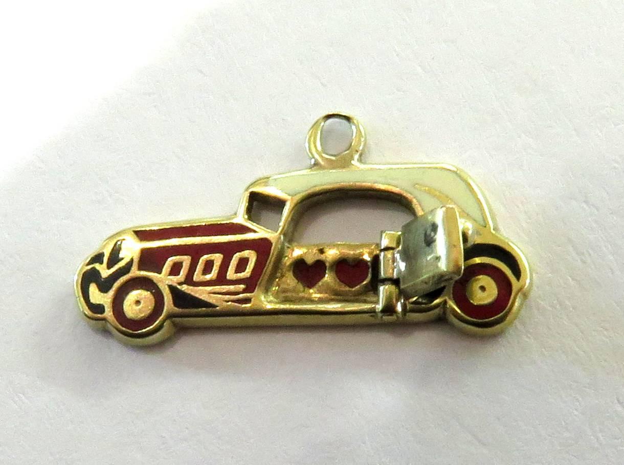 I think this car is a 1936 SS Jaguar 100 British 2-seat sports car. When the door is opened, it reveals two red enamel hearts. For such a tiny 14k charm, the enamel detail is amazing. This is a great addition to any rare deco charm bracelet or