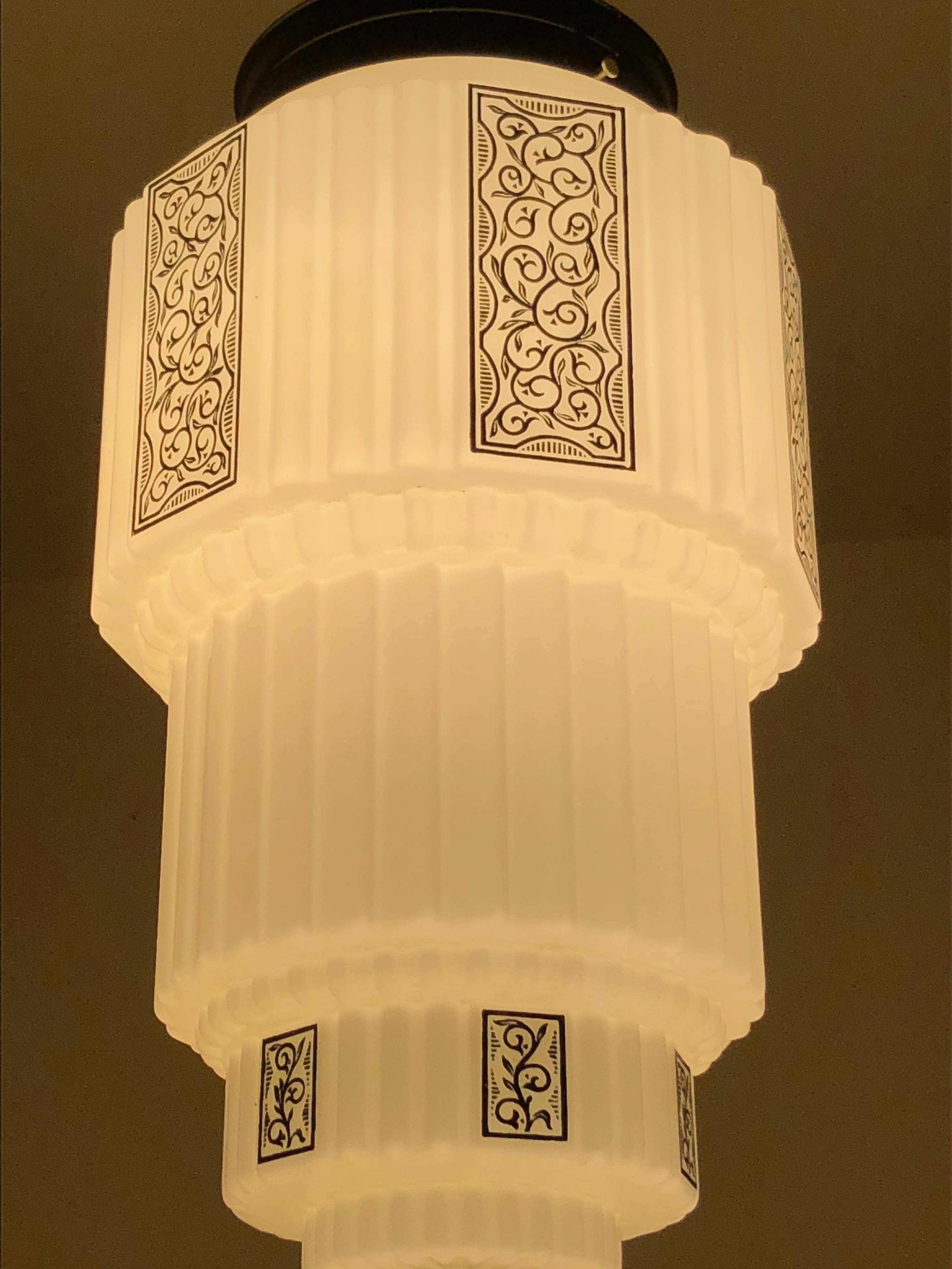 Rare Classic “wedding cake chandelier” with stepped and rounded streamline treatment. A very pleasing design and shape. Nice deco graphic pattern surrounds this stunning piece both at the top and the bottom. Right now we have three matching globes,
