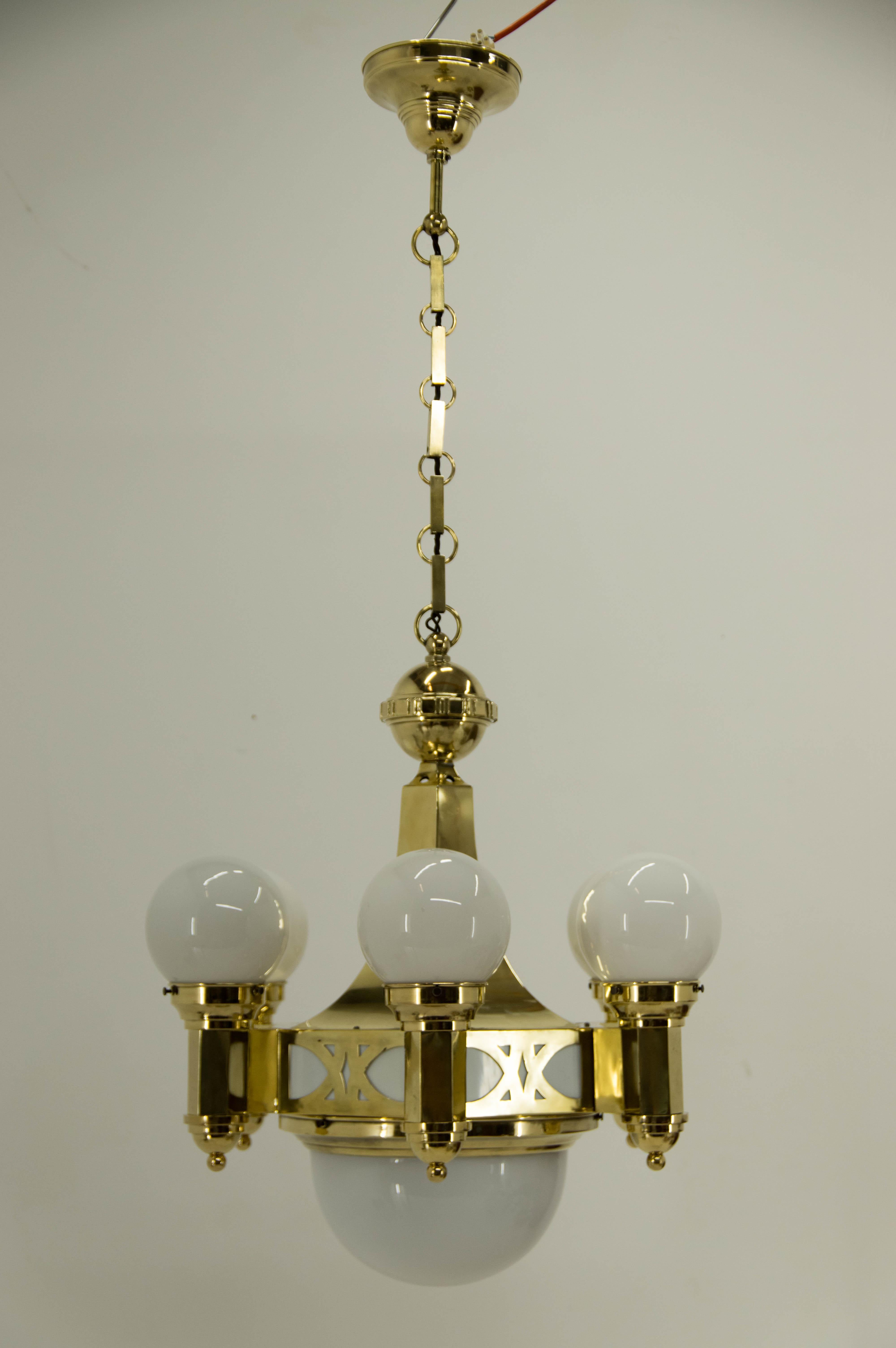 Very rare late Art Nouveau brass chandelier designed by architect Emil Kralik. 
Probably manufactured in Vulkania Prostejov where Kralik was a director.
Item was completely restored, brass refinished and polished.
One cca 3cm crack on one arm was