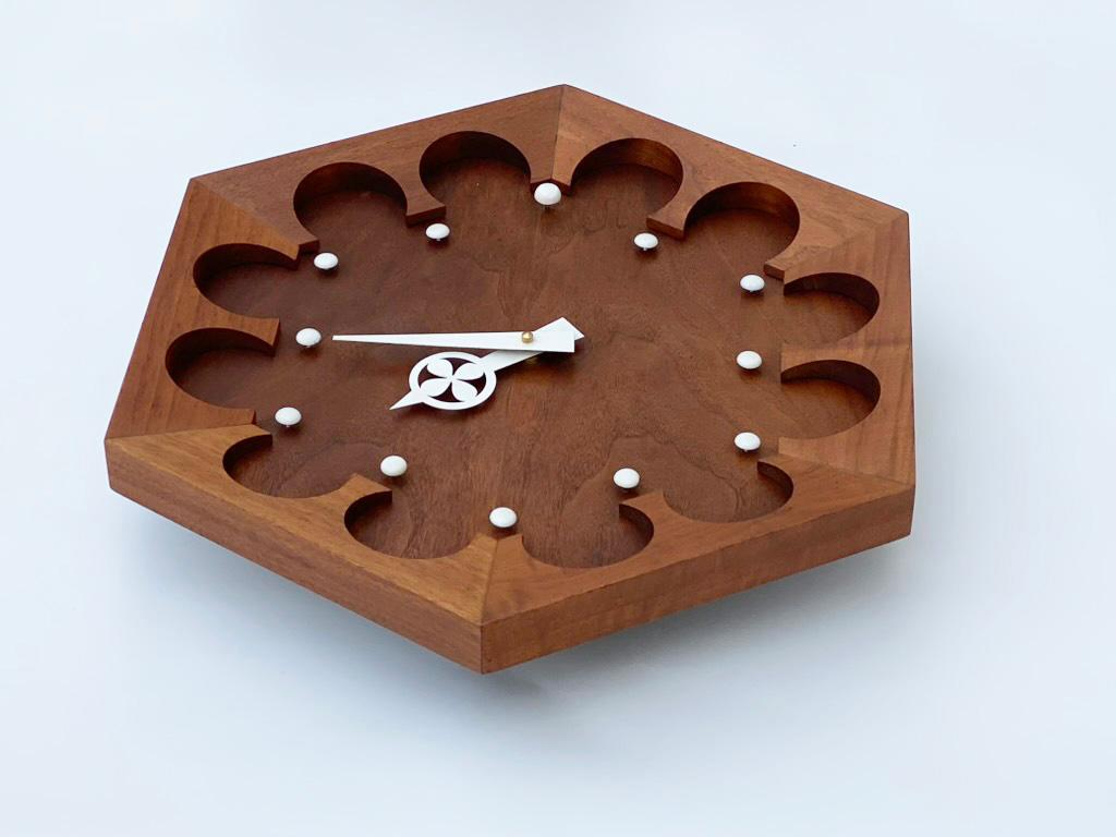 Here is a rare and very graphic wall clock designed by Arthur Umanoff for Howard Miller during the reign of George Nelson. Made of oiled walnut with white hour indicators and hands, this example is in very good condition. The wood is very clean. The