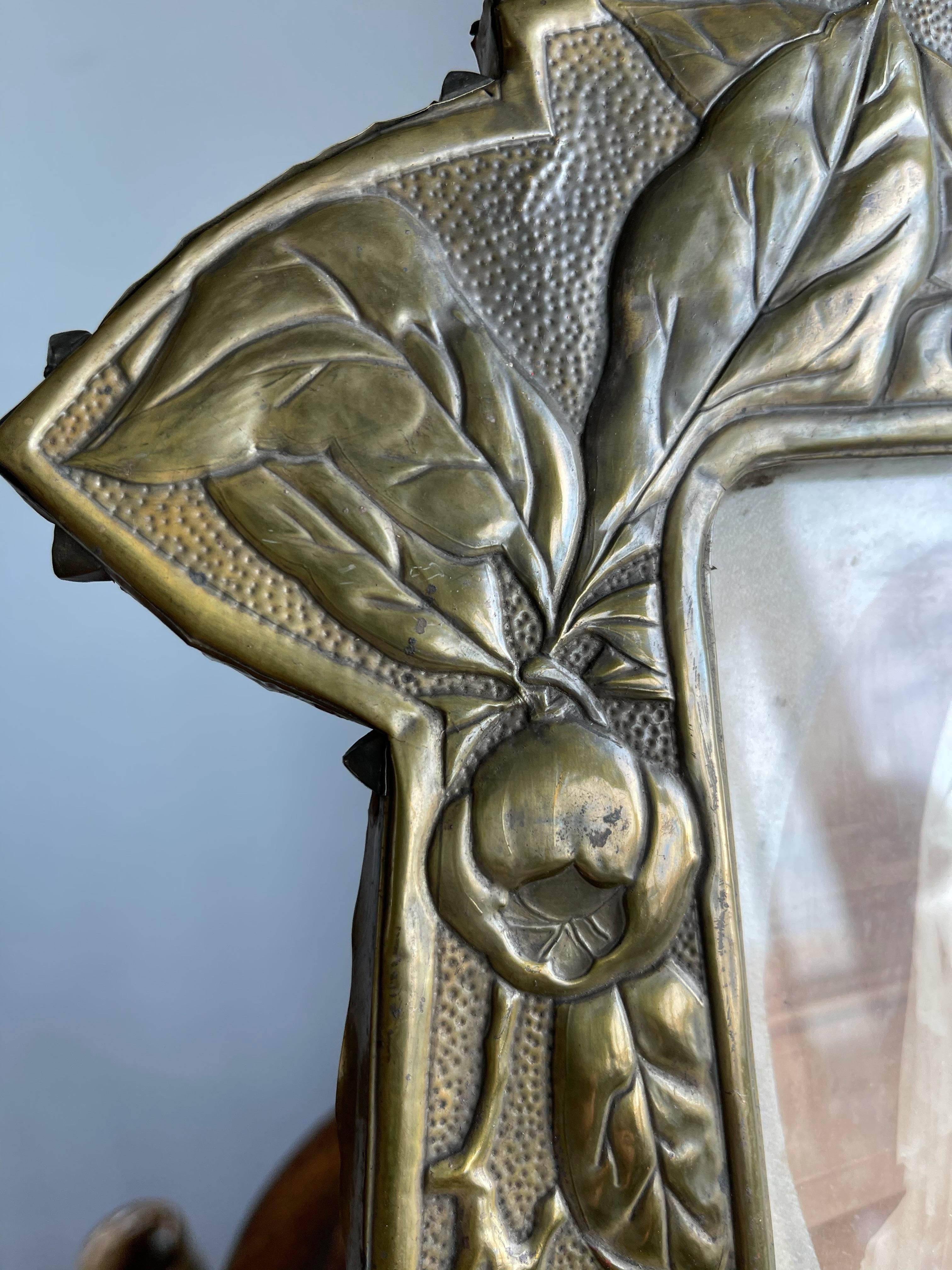 Exceptional brass on wood desk picture frame with a rare and marvelous decor. 

If you are a collector of rare and great looking Arts & Crafts antiques in general and if the rose hip (aka rose haw) holds a special place in your heart as well then