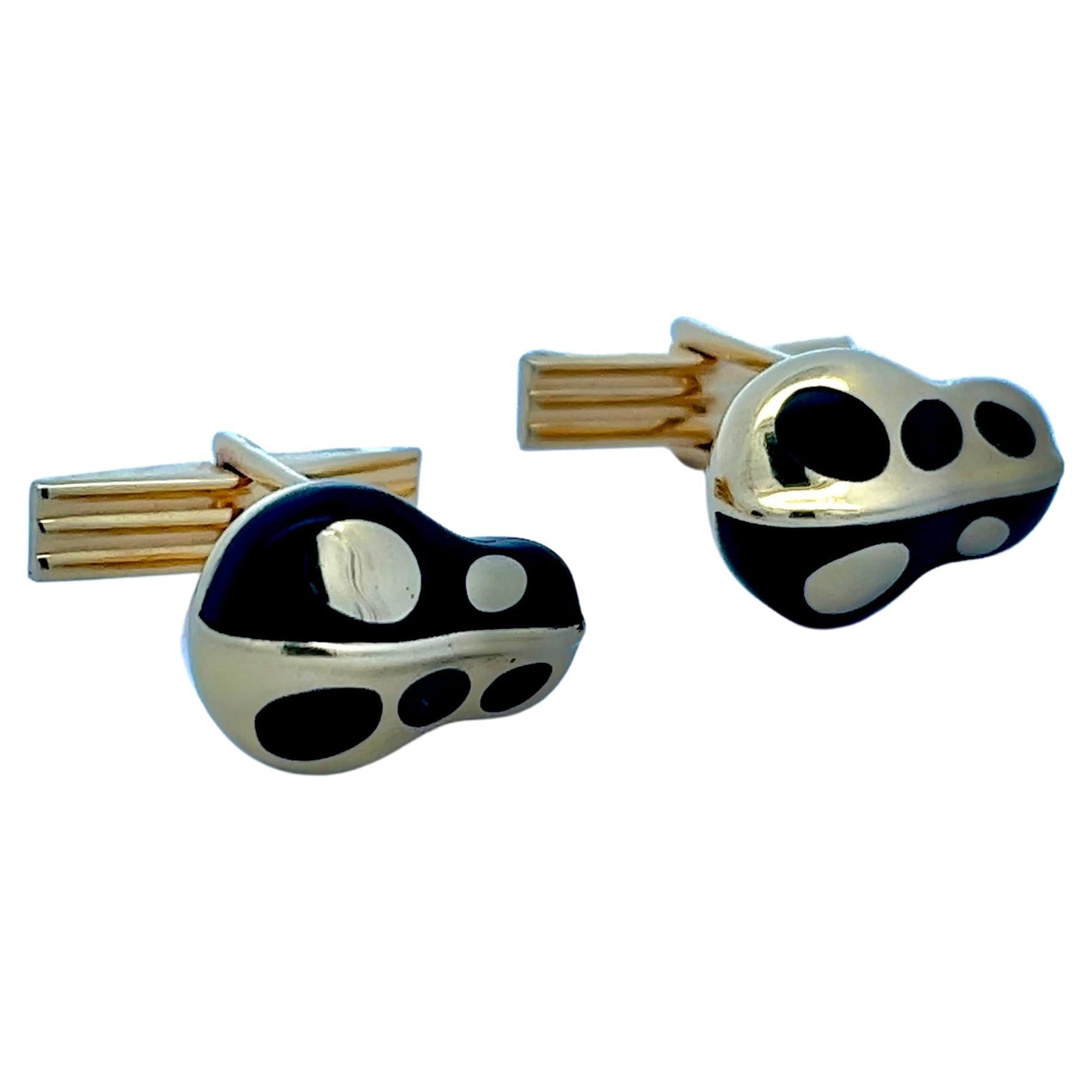 These meticulously crafted cufflinks is a rare piece from the esteemed Asch Grossbardt collection. These cufflinks, with their harmonious blend of yellow gold and inlaid onyx, are emblematic of the brand's aesthetic. The design, subtly reminiscent