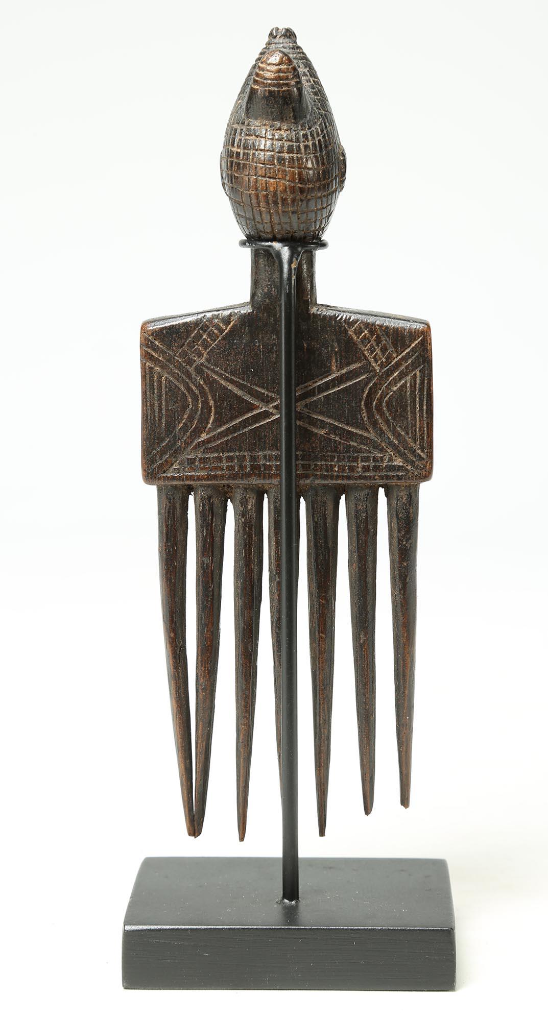 Expertly carved Attie comb with female form, Cote d'Ivoire, early 20th century. Wood with deep patina. Measures: 6
