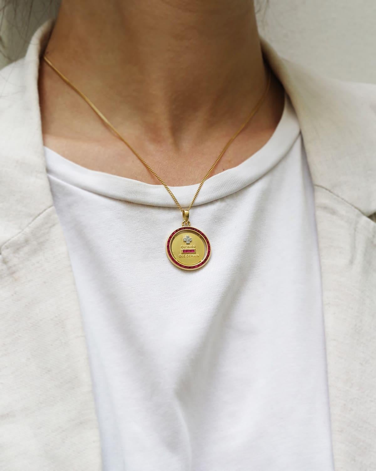 Augis Halo Rubin Love Medaille in 18 Karat Gold. Seltene Augis-Liebesmedaille in runder Form mit einer Umrandung aus 27 kalibrierten synthetischen Rubinen. Das 