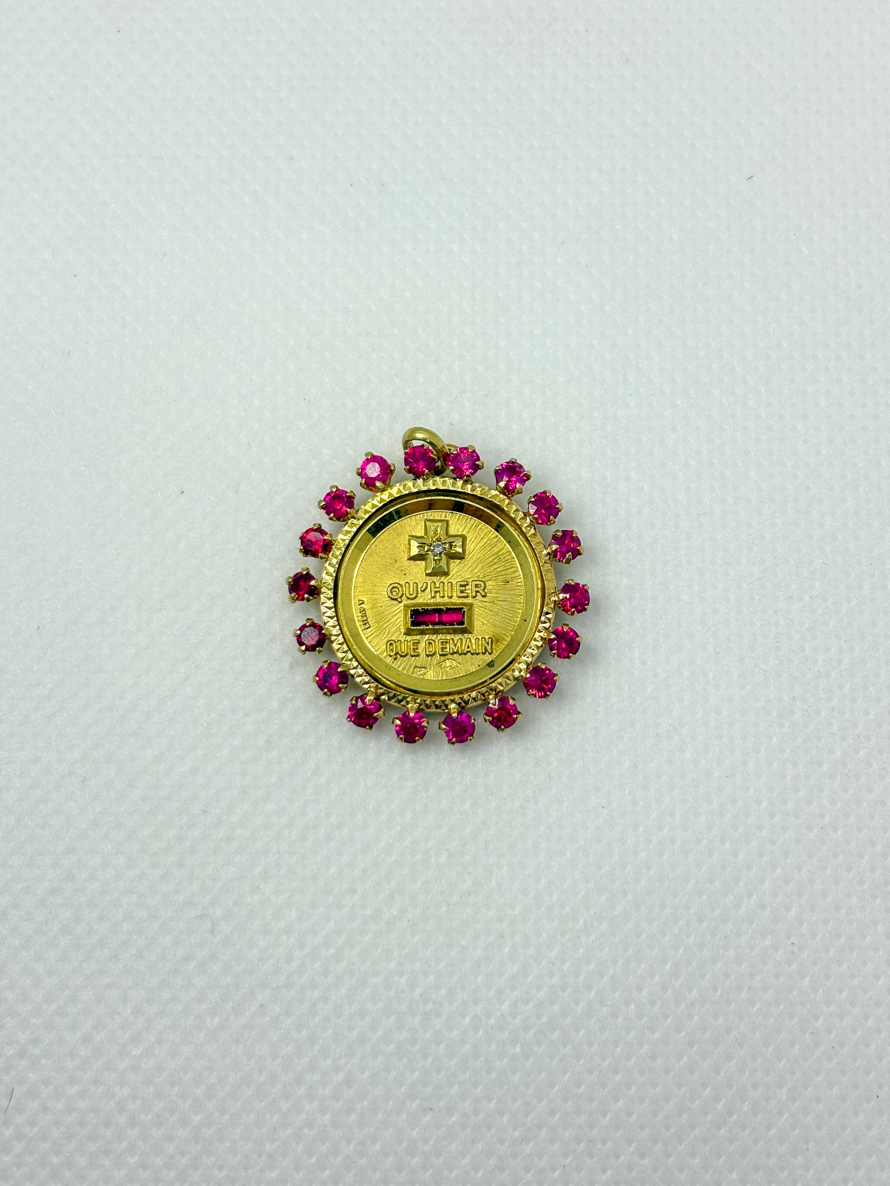 Eccezionale e altamente collezionabile medaglia A. Augis in oro giallo 18 carati, circondata da un superbo alone di rubini corindone rosso vivo (rubini sintetici). Questa lussuosa cornice esalta l'iconico design di A. Augis ispirato alla celebre