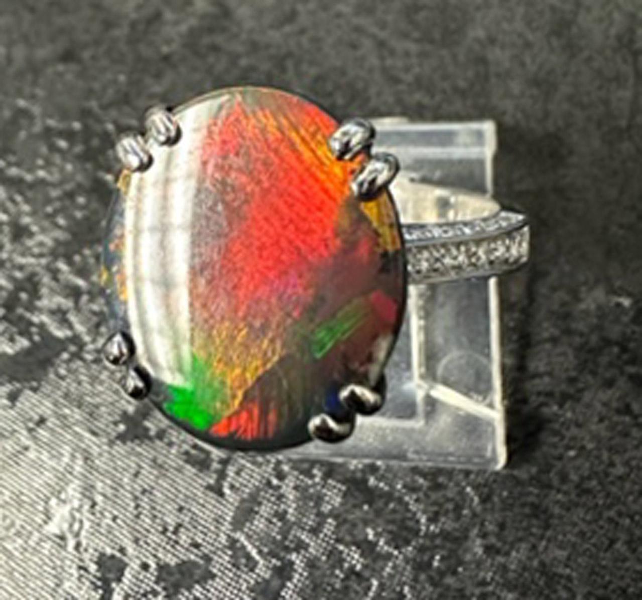 A rare and truly amazing Australian Lightning Ridge black opal is the center piece of this lovely handcrafted white gold diamond ring. The black opal weighing 4.89 carats is accompanied by a report from the AGL stating that this opal is natural with