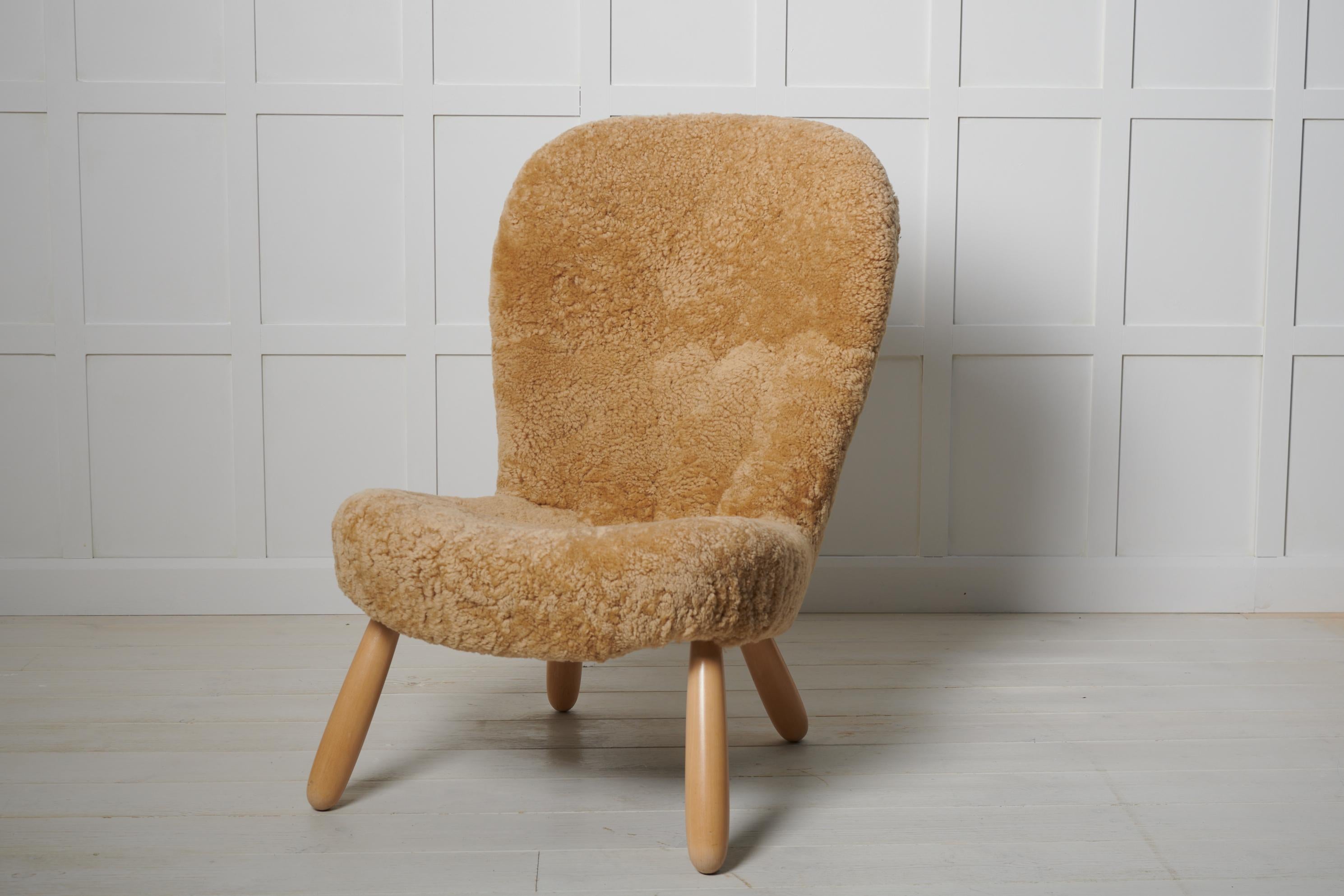 Rare Scandinavian modern Clam Chair by Arnold Madsen and produced by Madsen & Schubell. This chair is a genuine vintage chair made in Denmark during the 1940s. It has recently been completely restored and upholstered with sheepskin from Skandilock.