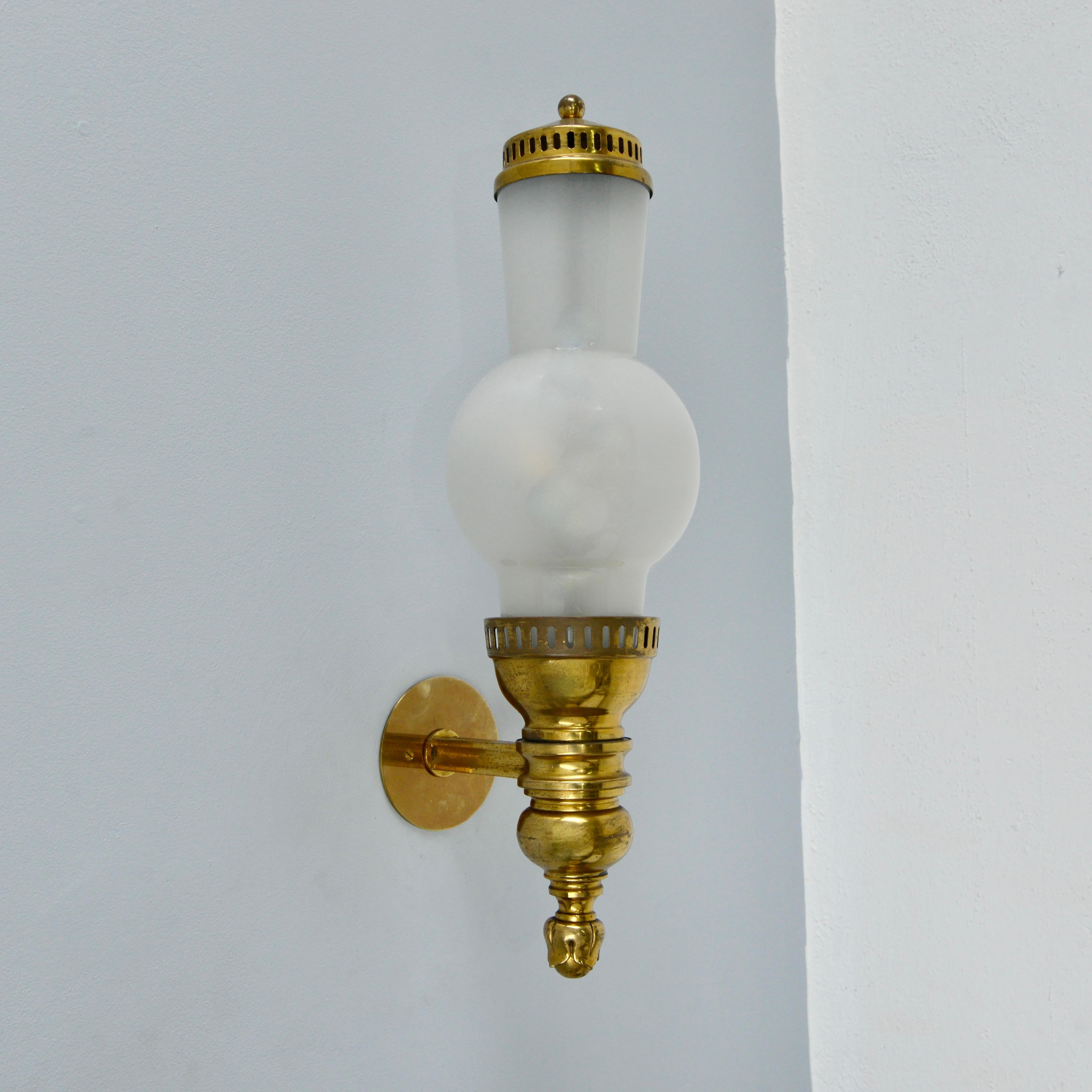 Delightful large 1940s single Italian brass and glass lantern/sconce by Caccia Dominioni for Azucena. Soft white glass shade with naturally aged brass. Partially restored with 2 E12 candelabra based sockets for use in the USA. It can also be wired
