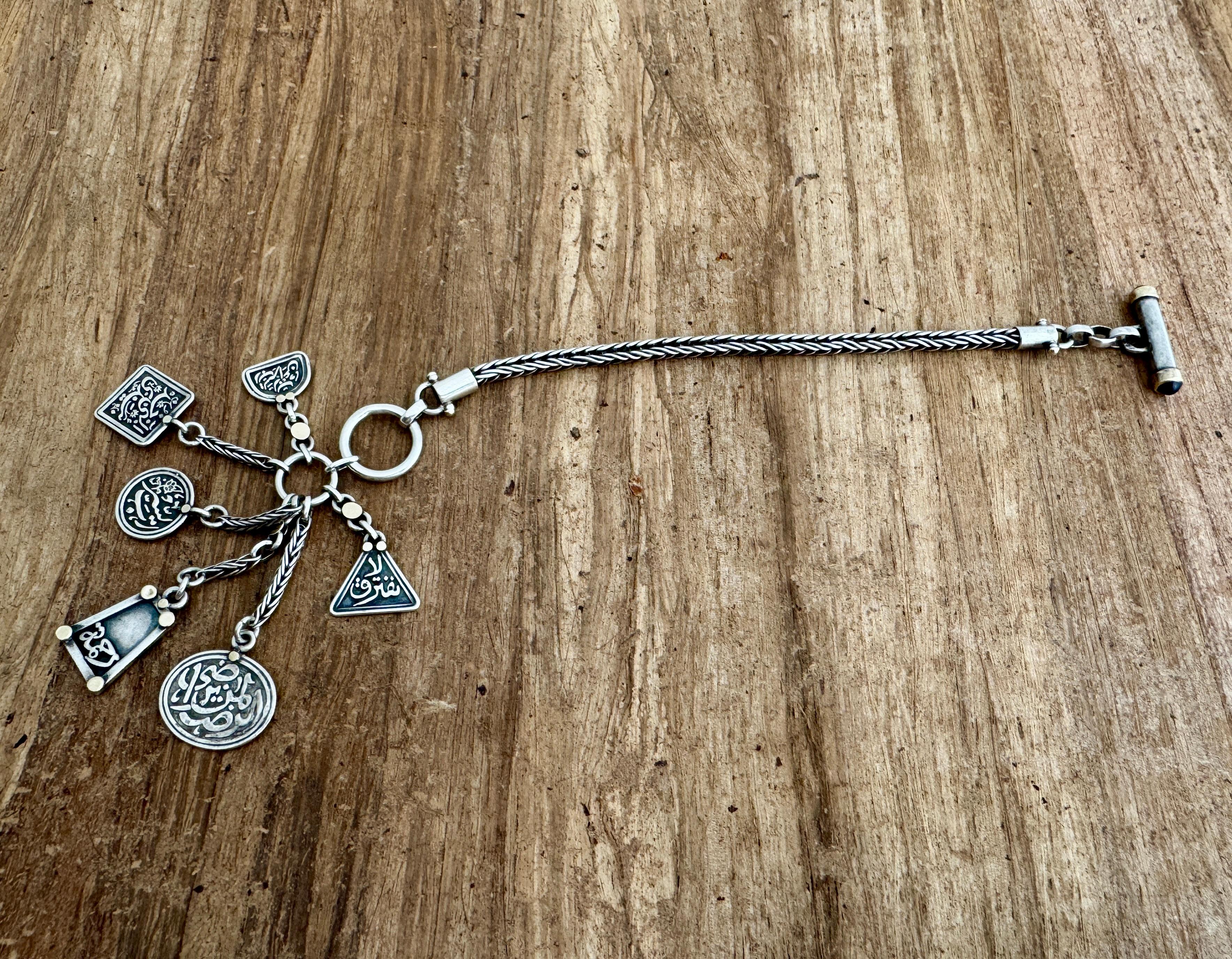Egyptian jewelry artist Azza Fahmy Sterling Silver & Gold Multi Charms Bracelet(Six Charms stating لا نفترق , الرضا لمن يرضى, رب يسر, النبى خذ بيدى, رحمه, رب يسر رب اعن ), Features Gold Details And Dark Jewel On The Tip. Marks on  