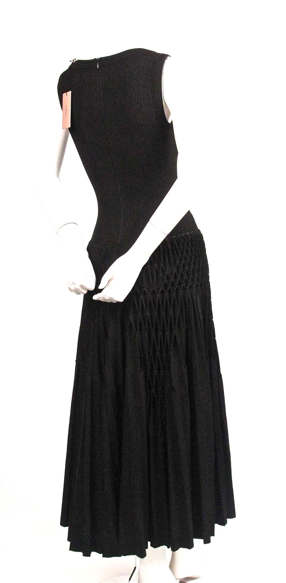 Jet-black, knit 'Plissé Abeille' dress from Azzedine Alaia dating to 2014 and seen on the runway. Dress is labeled a French size 38. Approximate un-stretched measurements: shoulder 13