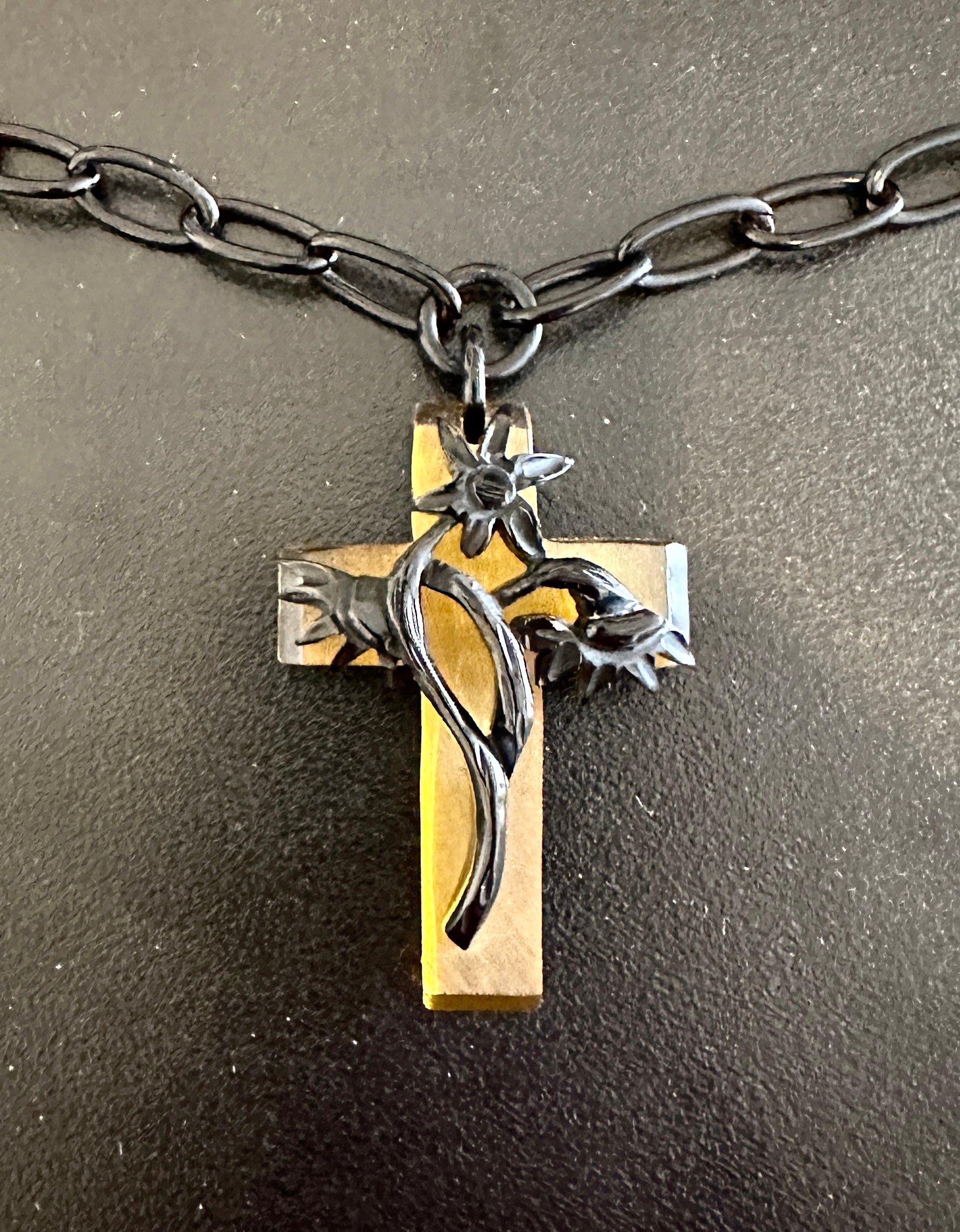 Indulge in a magnificent rare antique Art Deco Bakelite Cross Pendant Necklace.  The stunning cross is adorned with a fully three dimensional flower.  The dramatic use of the honey colored bakelite cross with the black flower is absolutely