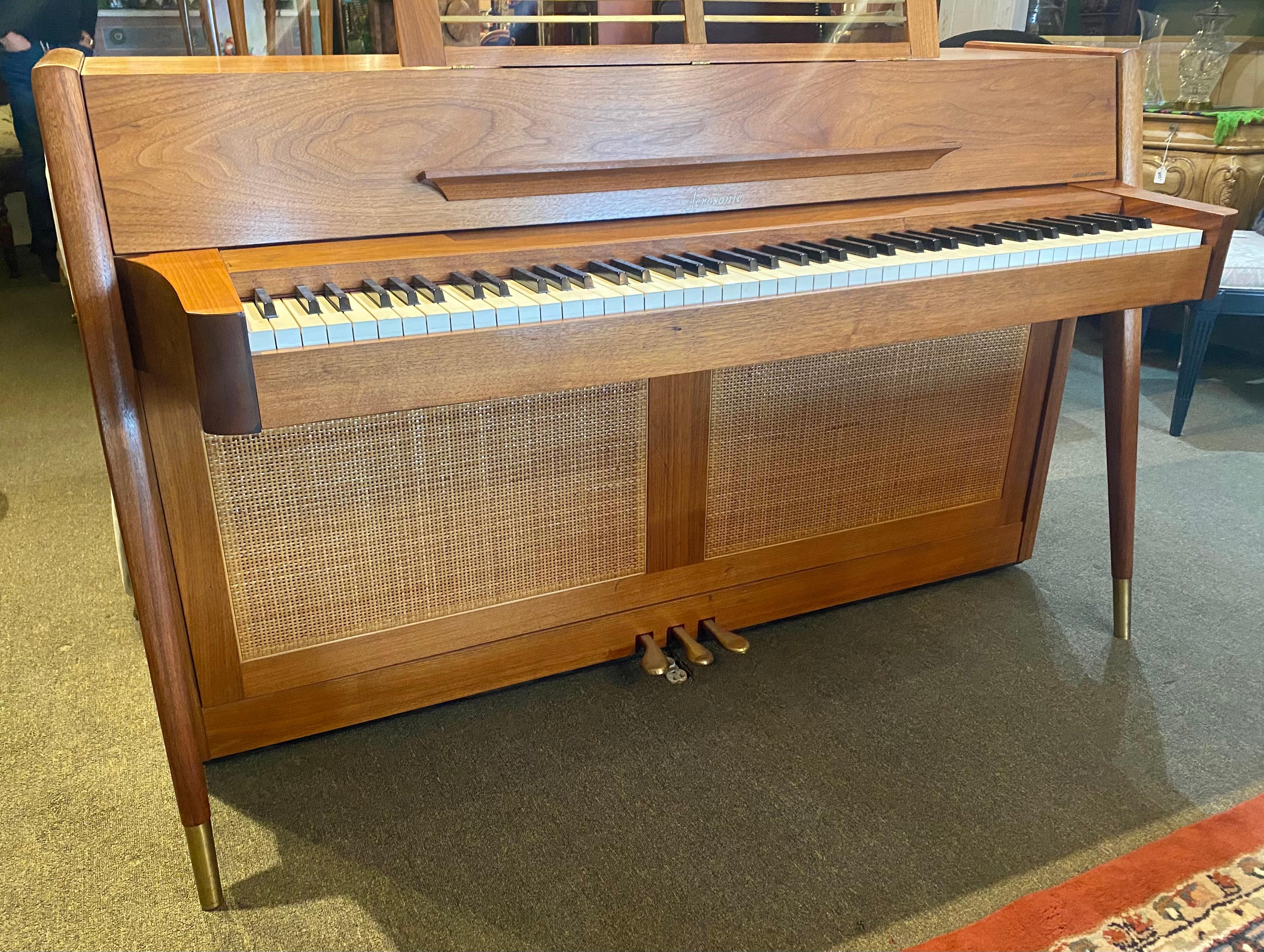 

Gorgeous Modernist Baldwin Arcosonic Spinet Piano.. Note the dramatic angled legs and striking wood grain, The back side of the piano is fully finished with walnut and cain panels so it can be placed anywhere in a room.Small in size ,big in