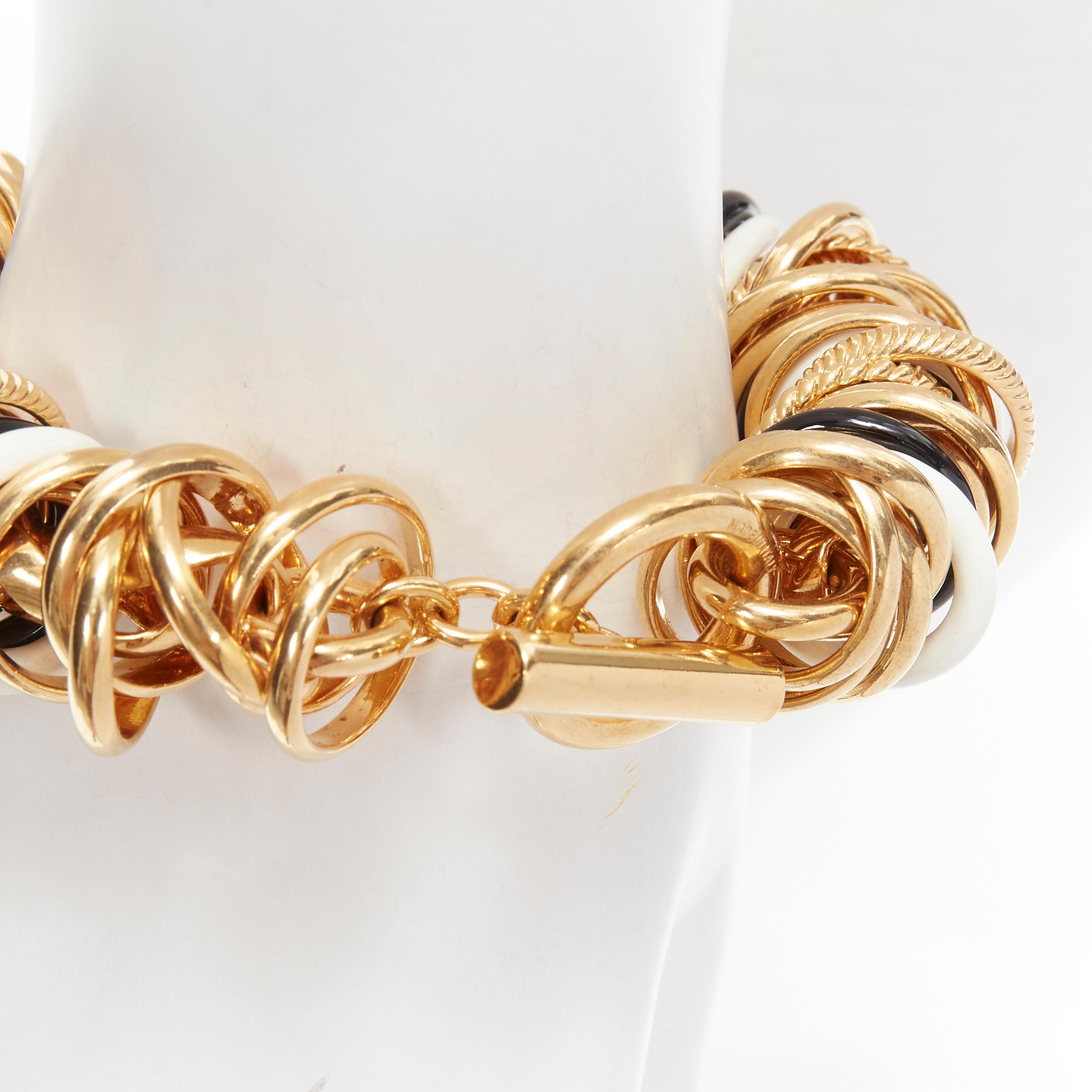 rare BALENCIAGA Demna Artisanal multi gold black white rings linked bracelet
Brand: Balenciaga
Designer: Demna
Material: Metal
Color: Gold
Pattern: Solid
Closure: Toggle
Extra Detail: Designed to look like a hundred rings were linked together onto a