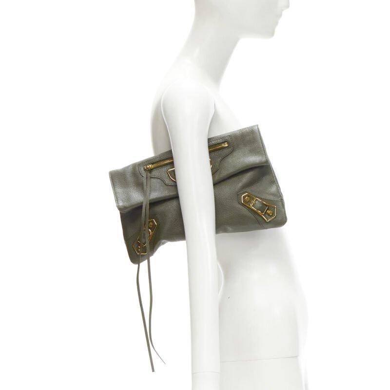 rare BALENCIAGA khaki green leather gold buckle Motocross flap clutch bag
Reference: KEDG/A00170
Brand: Balenciaga
Model: Motocross clutch
Material: Leather
Color: Green, Gold
Pattern: Solid
Closure: Magnet
Lining:  Fabric
Extra Details: Mirrored