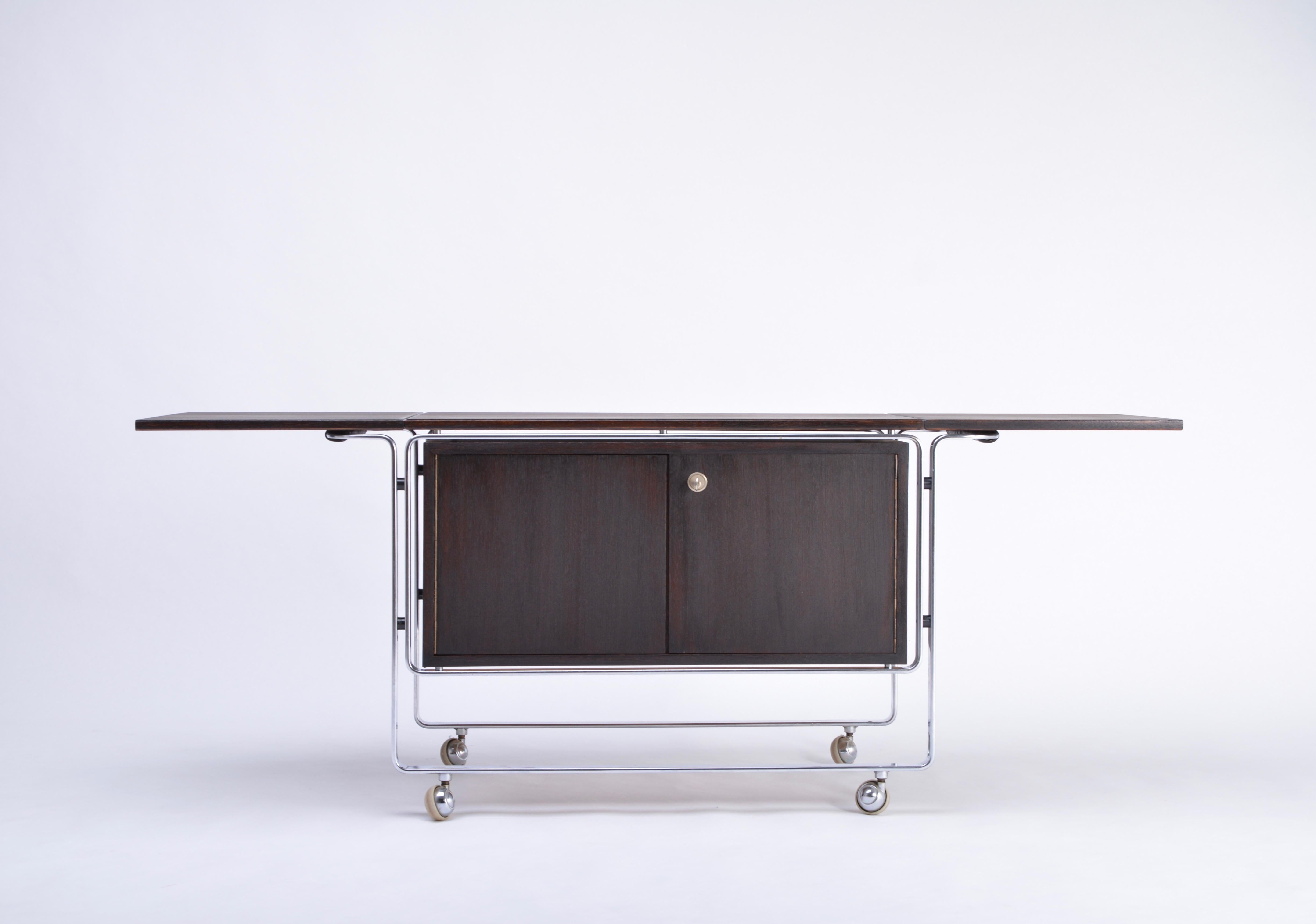 Rare bar cart designed by Horst Brüning in the 1960s and produced by Kill International. The structure is made of steel and features four wheels, the corpus is made of Wengé wood. The bar has two lockable drawers and one large compartment. The top