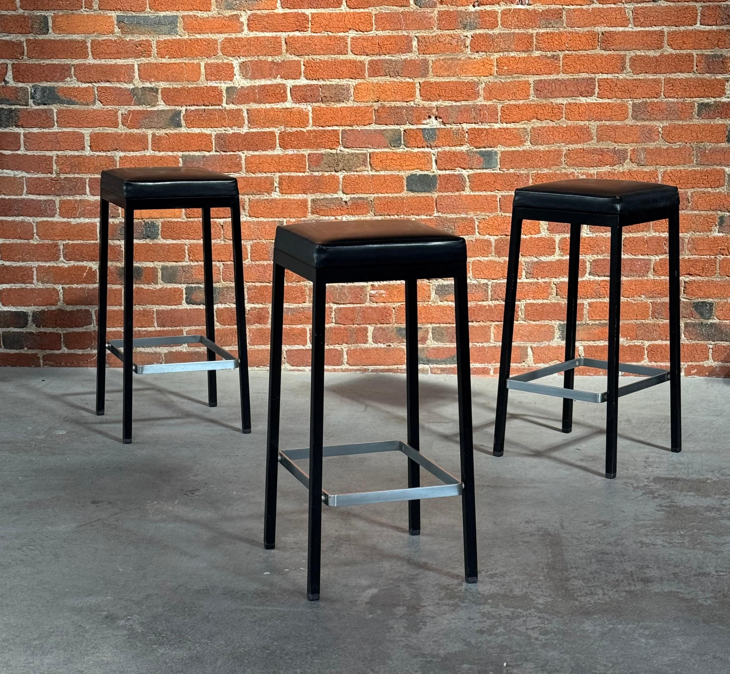 Juego de 3 taburetes de bar modernistas Knoll, una variante muy rara, con sólo un puñado de ellos disponibles en el mercado y que no aparecen en ninguno de sus catálogos. Con armazón de acero esmaltado negro y tapizado de naugahyde negro  asientos y