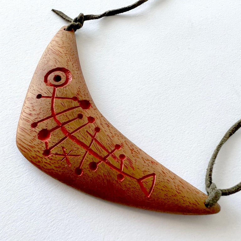 Rare, hand carved and painted boomerang shaped wood pendant created by Barney Reid of San Diego, California.  Pendant measures 4.75 by 2.5