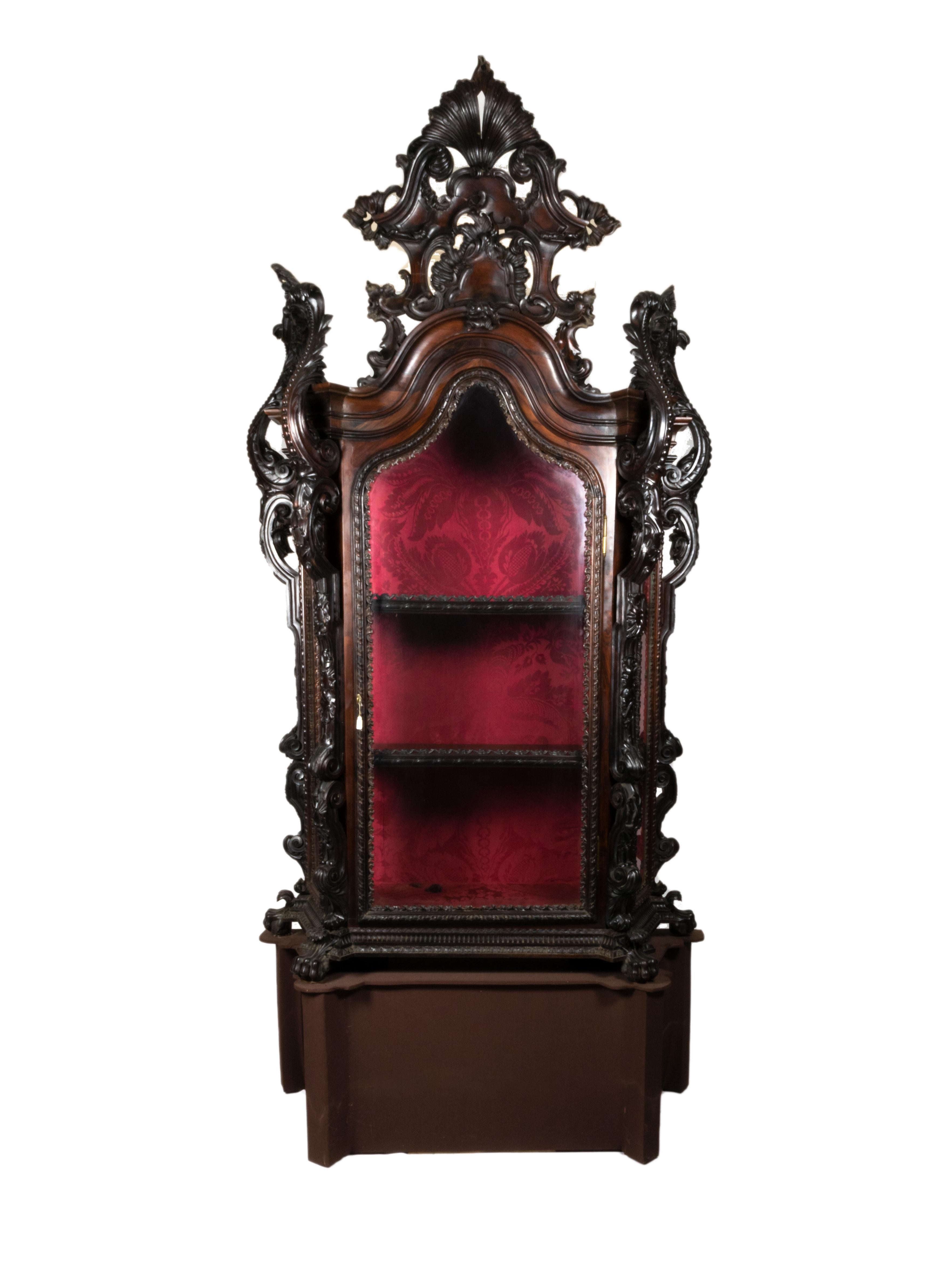 Rare rosewood oratory showcase, from the time of King Jose the I. 

Body surmounted by richly carved and fenestrated front and side headboards, glazed and framed door and sides with curvilinear cutouts in the upper segments. 

Side columns carved